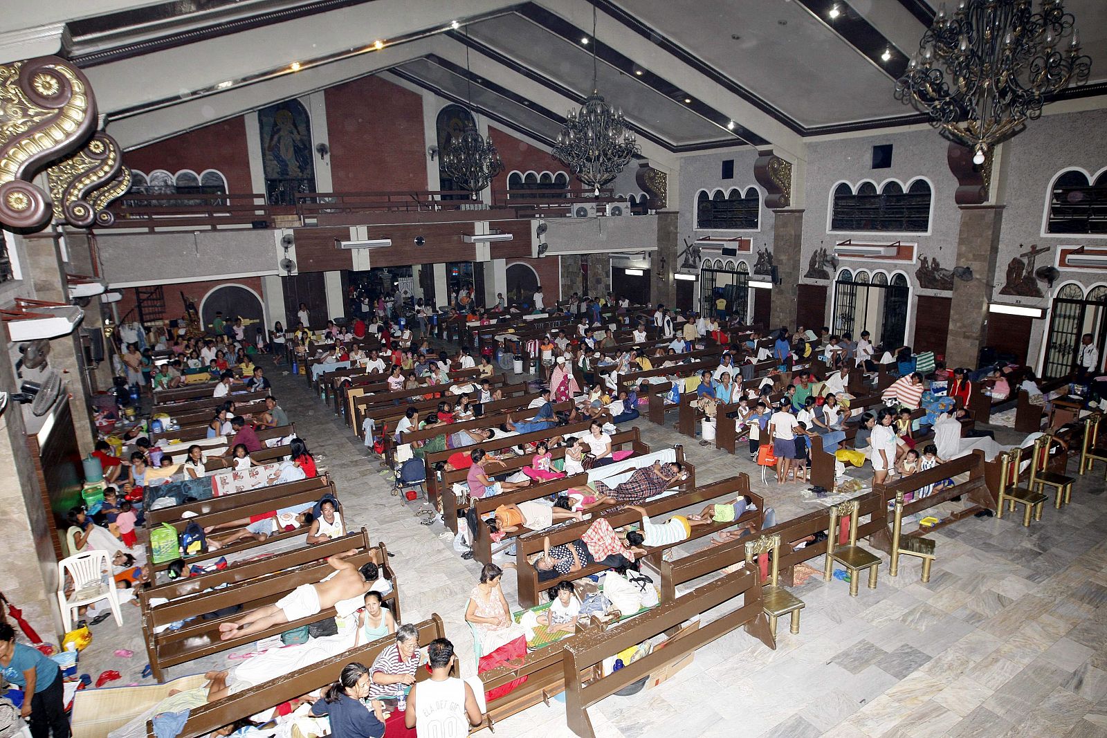Filipinos afectados por el 'Ketsana' descansan en un refugio improvisado en una iglesia
