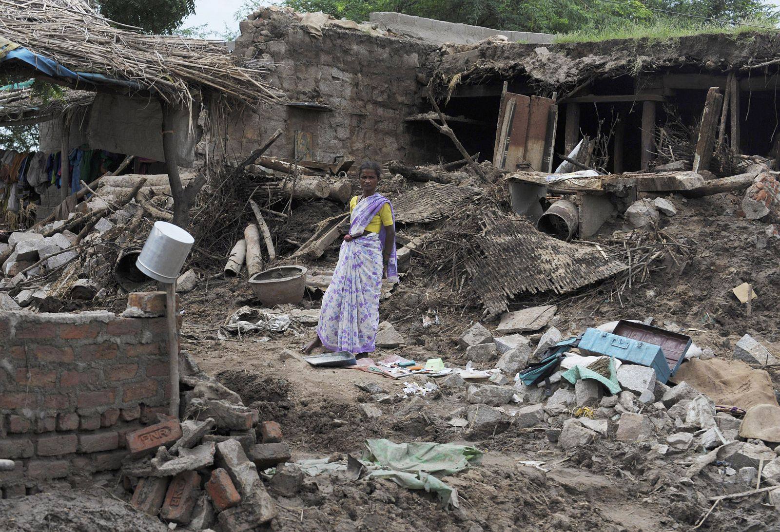 Una mujer observa su casa, reducida a escombros tras las inundaciones.