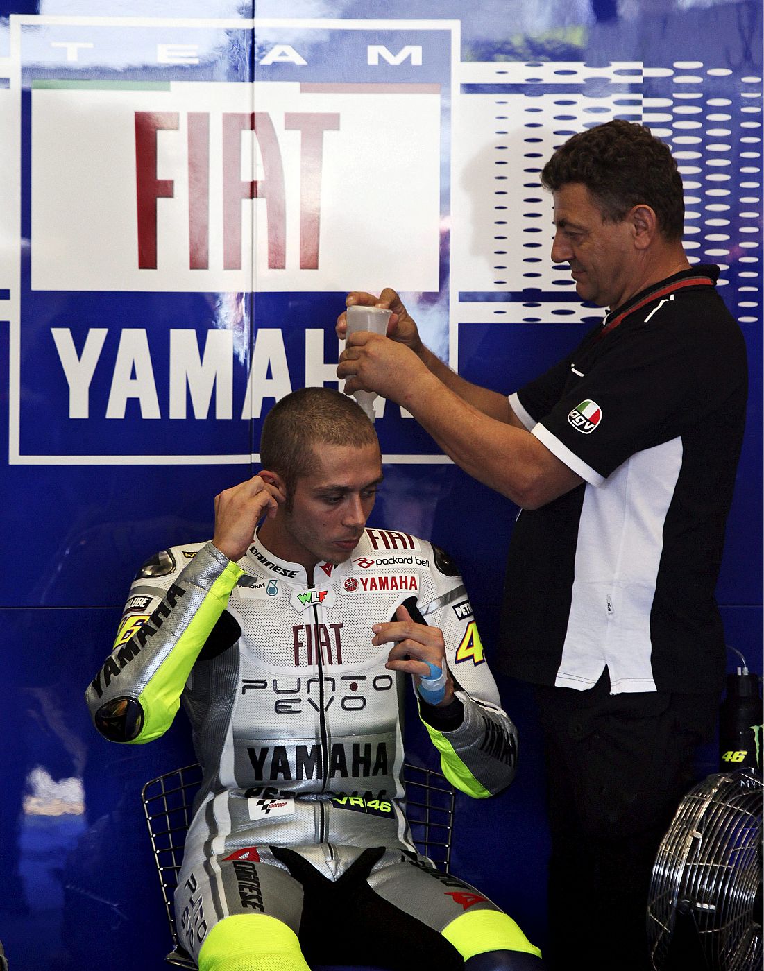 El piloto italiano Valentino Rossi (i), de Yamaha, habla con un técnico