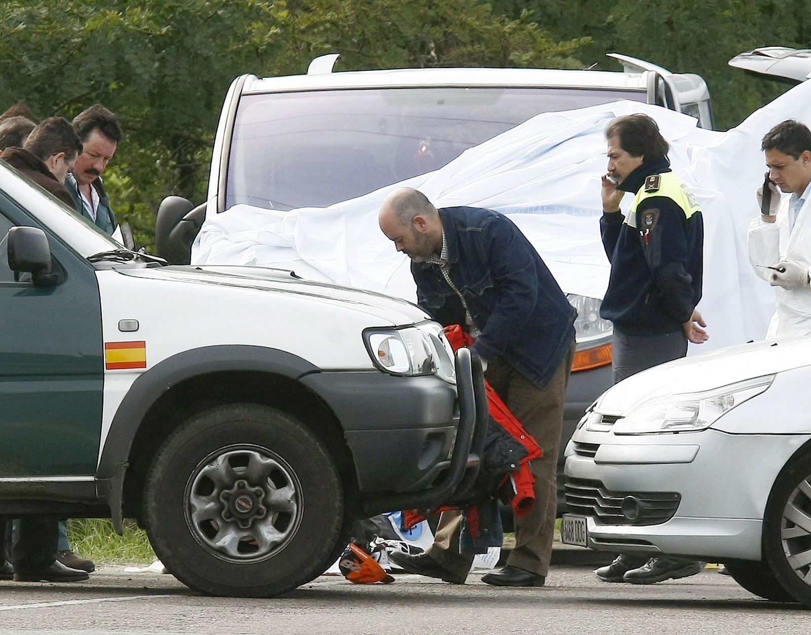 Agentes de la Guardia Civil inspeccionan algunas de las pertenencias de las tres personas que han sido asesinadas en el tiroteo que se ha producido en Santoña (Cantabria), junto a la furgoneta en la que se ha producido el crimen.