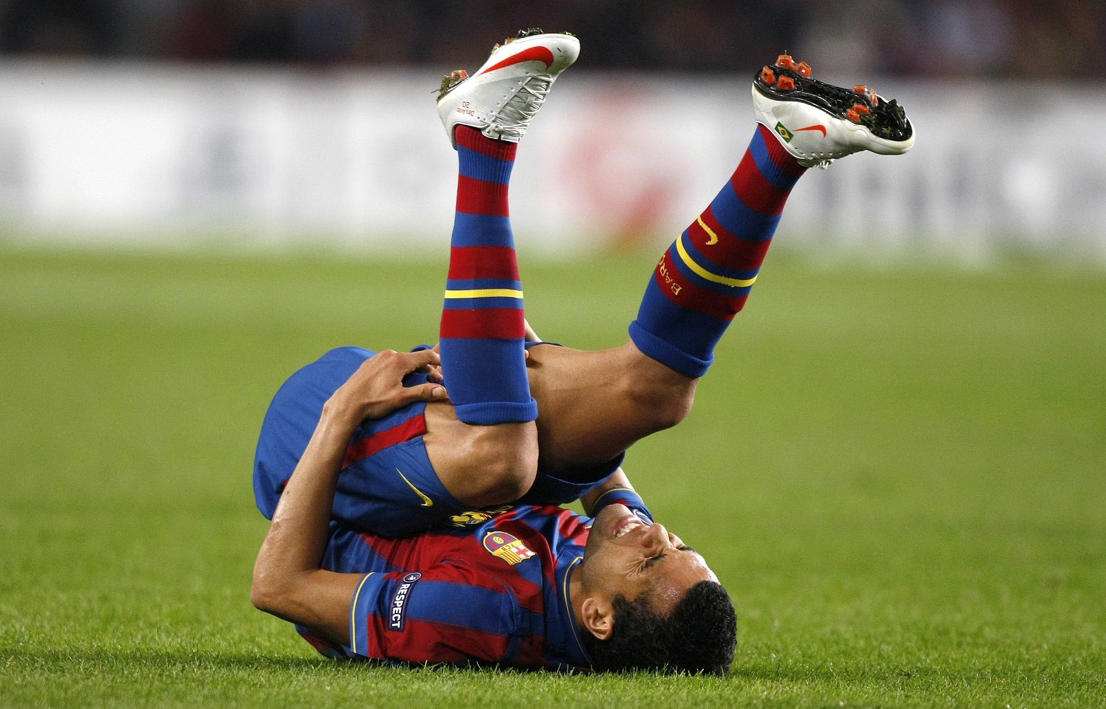 Barcelona's Dani Alves grimaces after being tackled by a Rubin Kazan player during their Champions League soccer match at the Camp Nou stadium in Barcelona