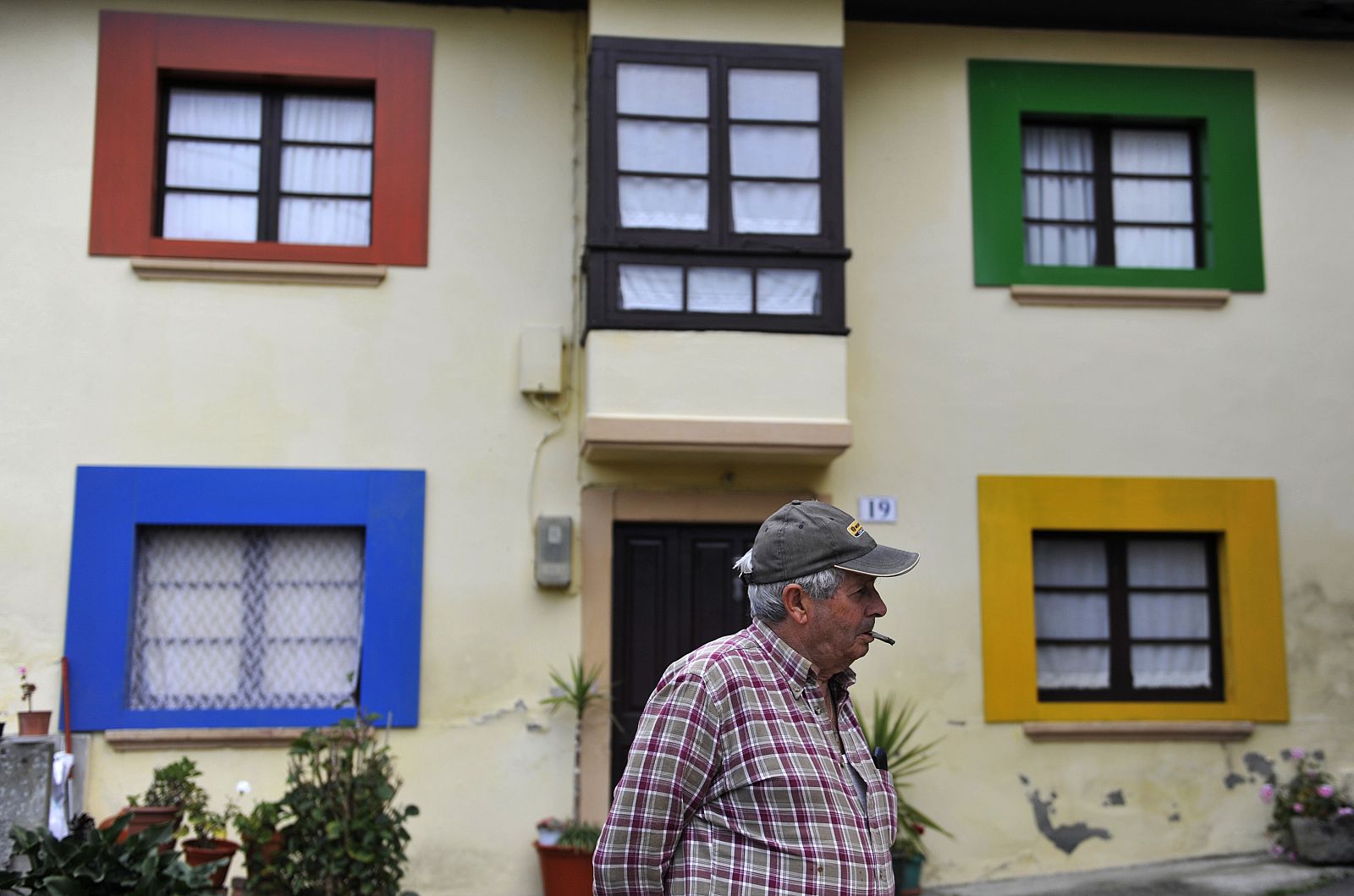 Un habitante de Sietes frente a una de las casas decoradas con los colores corporativos de Windows en el pequeño pueblo asturiano. El jueves 22 de octubre tendrá lugar en este pueblo el evento de lanzamiento de Windows 7.