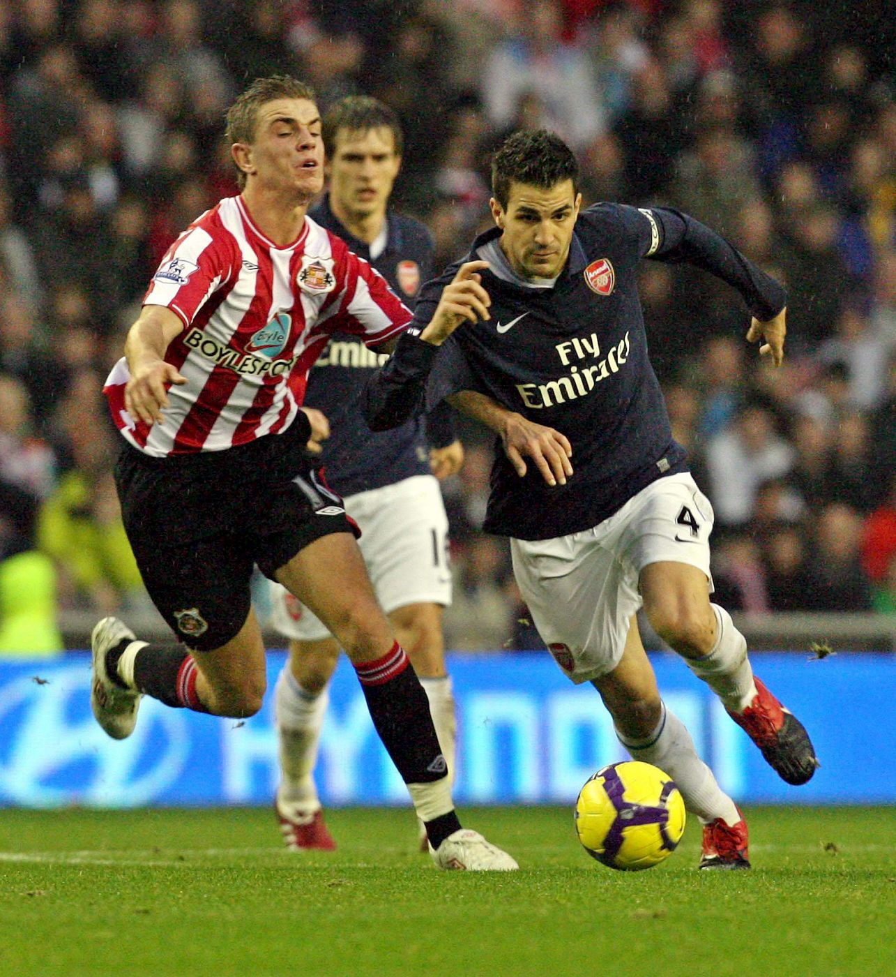 El volante derecho del Sunderland AFC, Jordan Henderson, lucha por el balón con el español Cesc Fábregas.