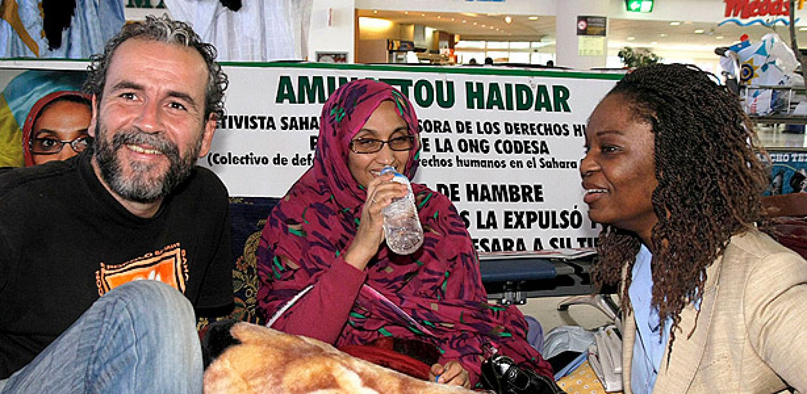 La representante del centro Robert F. Keneddy de Justicia y Derechos Humanos Boi Tia Stevens (d) y el actor Guillermo Toledo, durante la visita que han realizado a la activista Aminetu Haidar para interesarse por su estado de salud tras once días en huelga de hambre, hoy en el aeropuerto de Lanzarote.