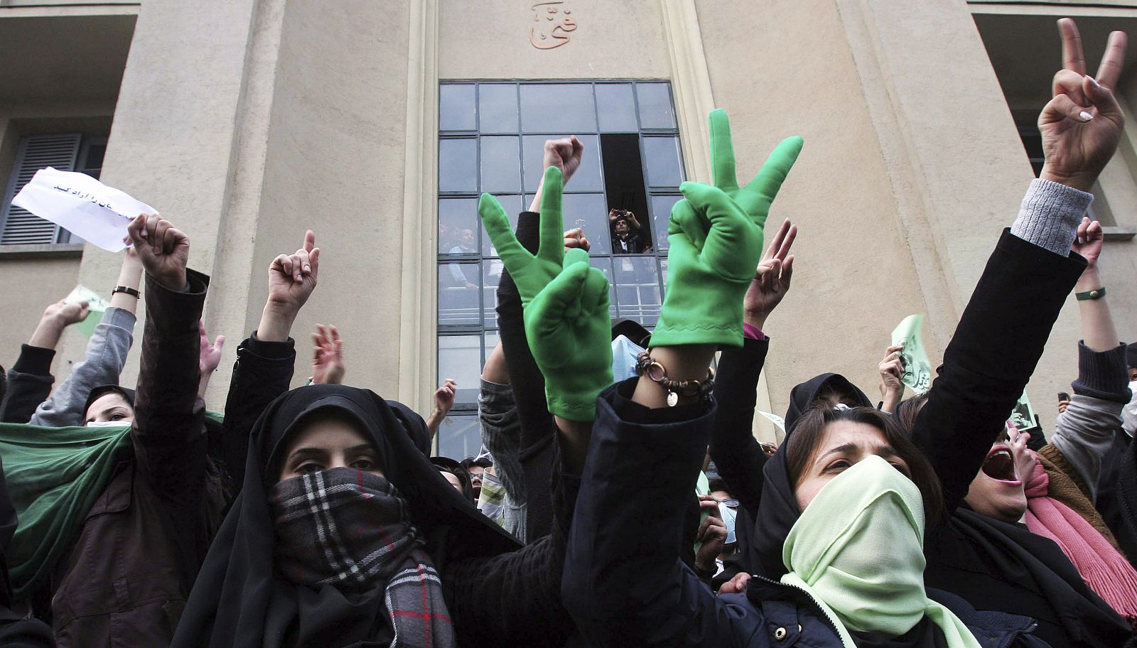 Estudiantes enmascarados muestran el signo de la victoria en las protestas en Teherán