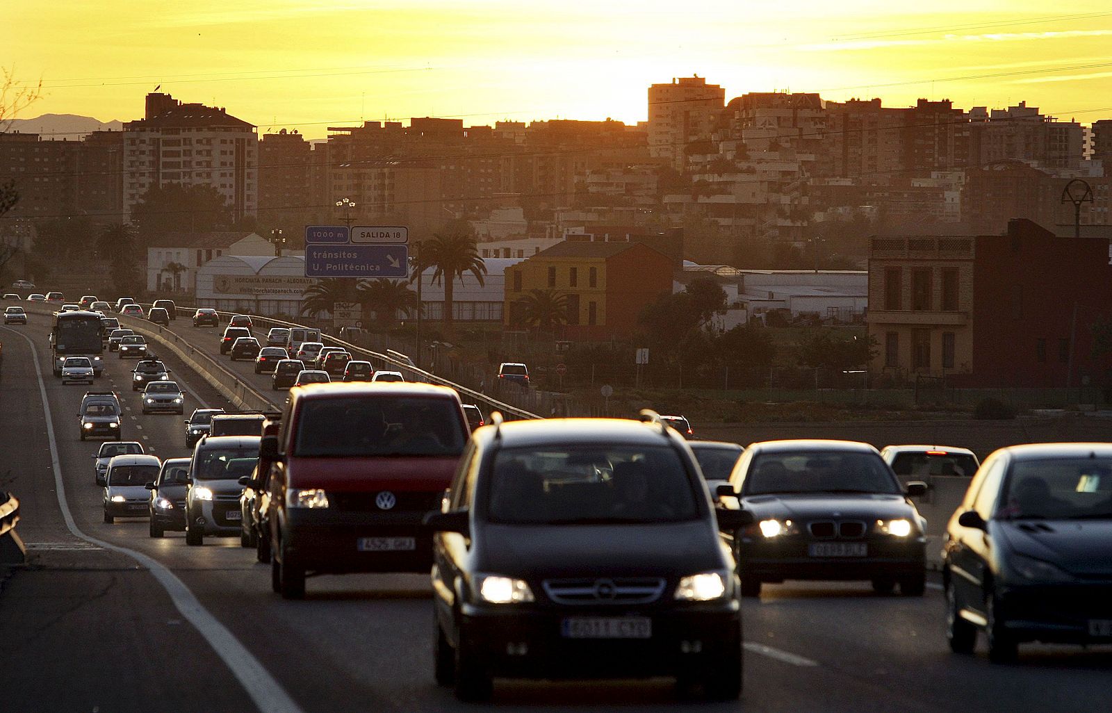 Numerosos coches circulan por una carretera al anochecer