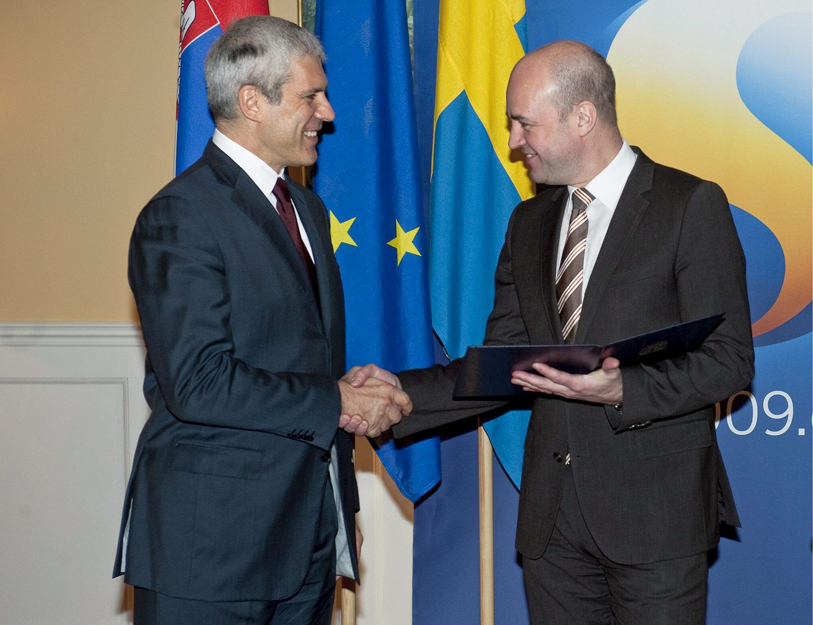 El presidente serbio Boris Tadic entrega al primer ministro de Suecia, Fredrik Reinfeldt, que ostenta la presidencia de turno de la Unión Europea, la solicitud oficial de su país para integrarse a la UE.