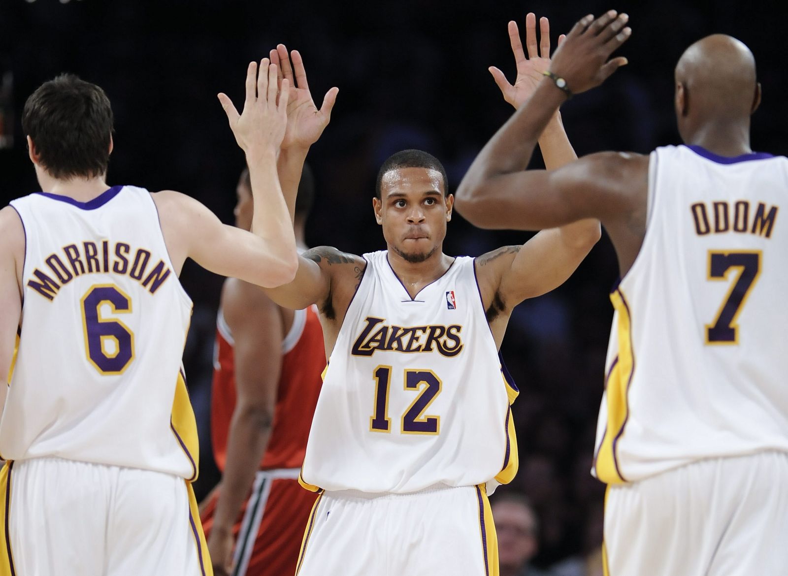 Los jugadores de los Lakers de Los Ángeles Shannon Brown (c), Adam Morrison (i) y Lamar Odom (d) celebran una canasta ante los Bucks