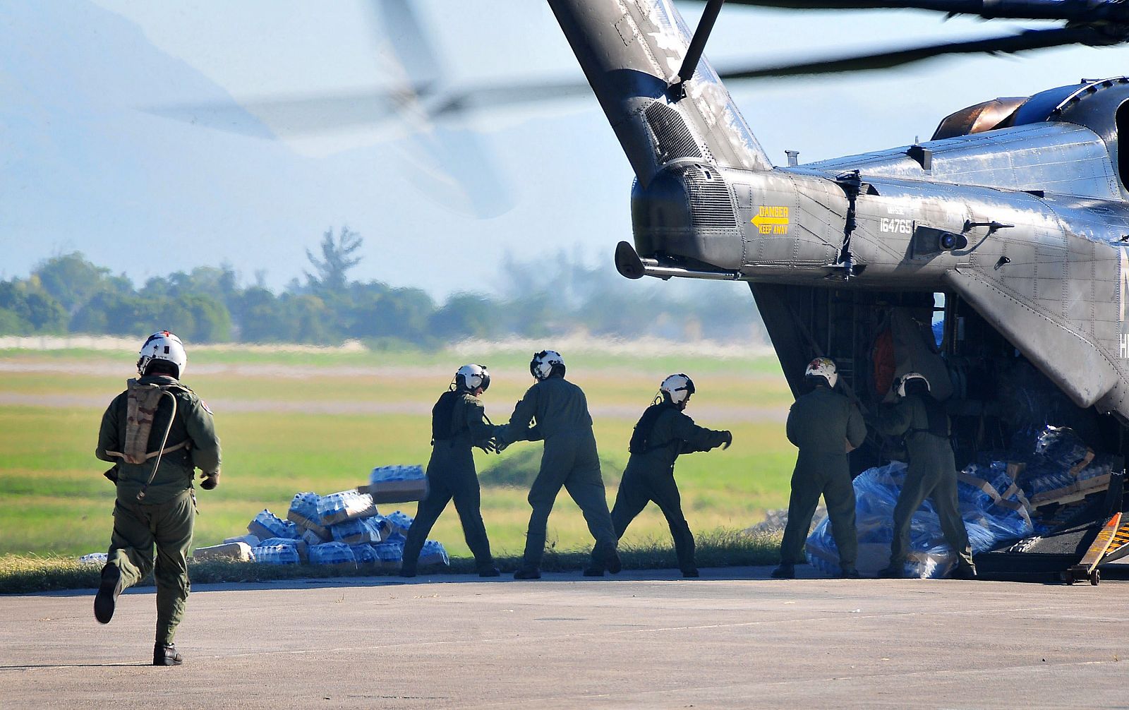Soldados estadounidense descargan alimentos y suministros de un helicóptero de la Marina en Puerto Príncipe.
