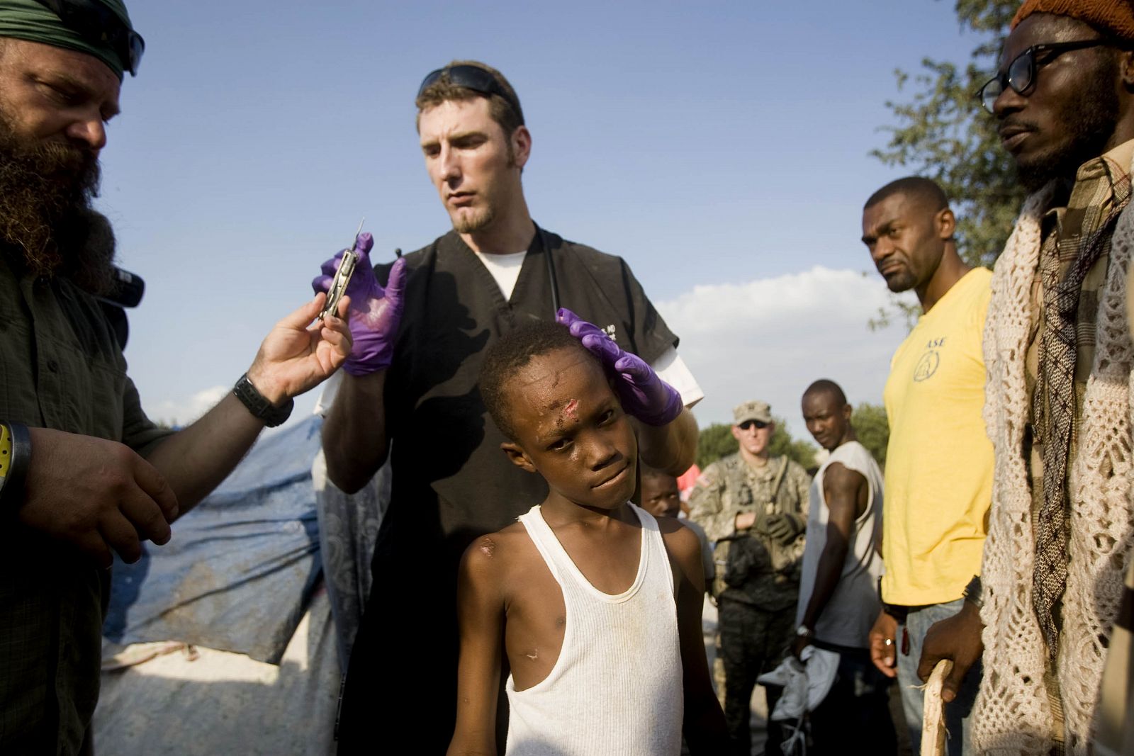 Un equipo médico de EE.UU. atiende a un niño herido en un refugio improvisado situado en un campo de golf en Puerto Príncipe.