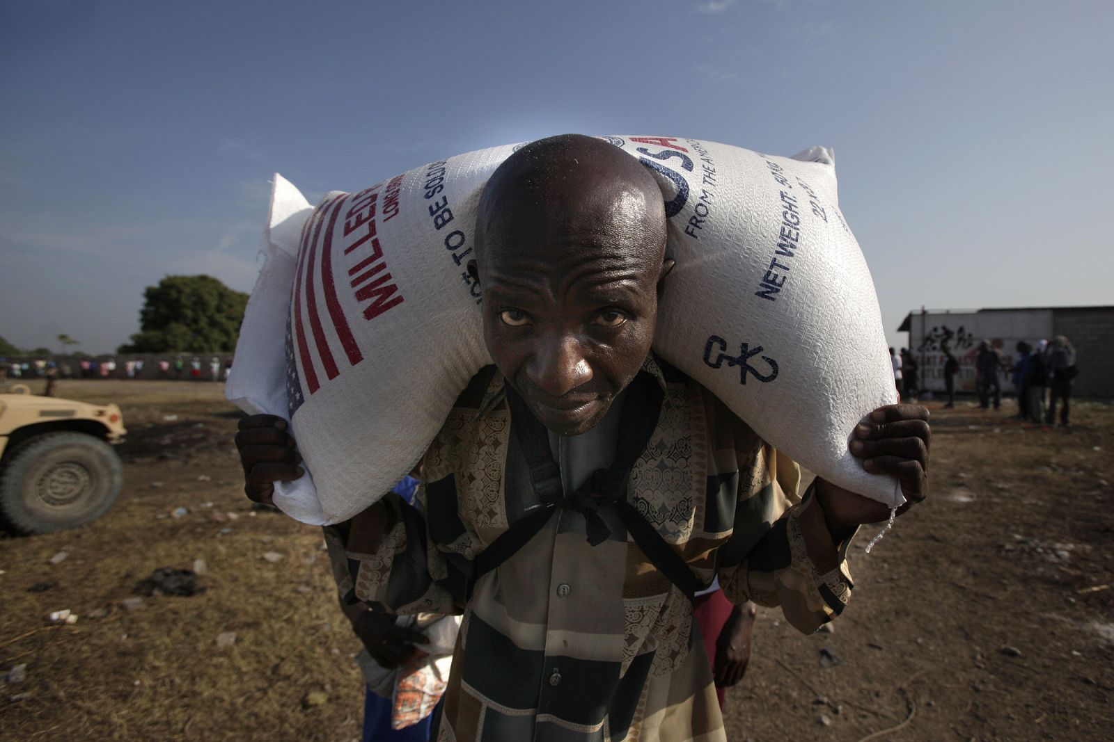 Un haitiano lleva un saco de arroz distribuido por las agencias de ayuda en Puerto Príncipe.