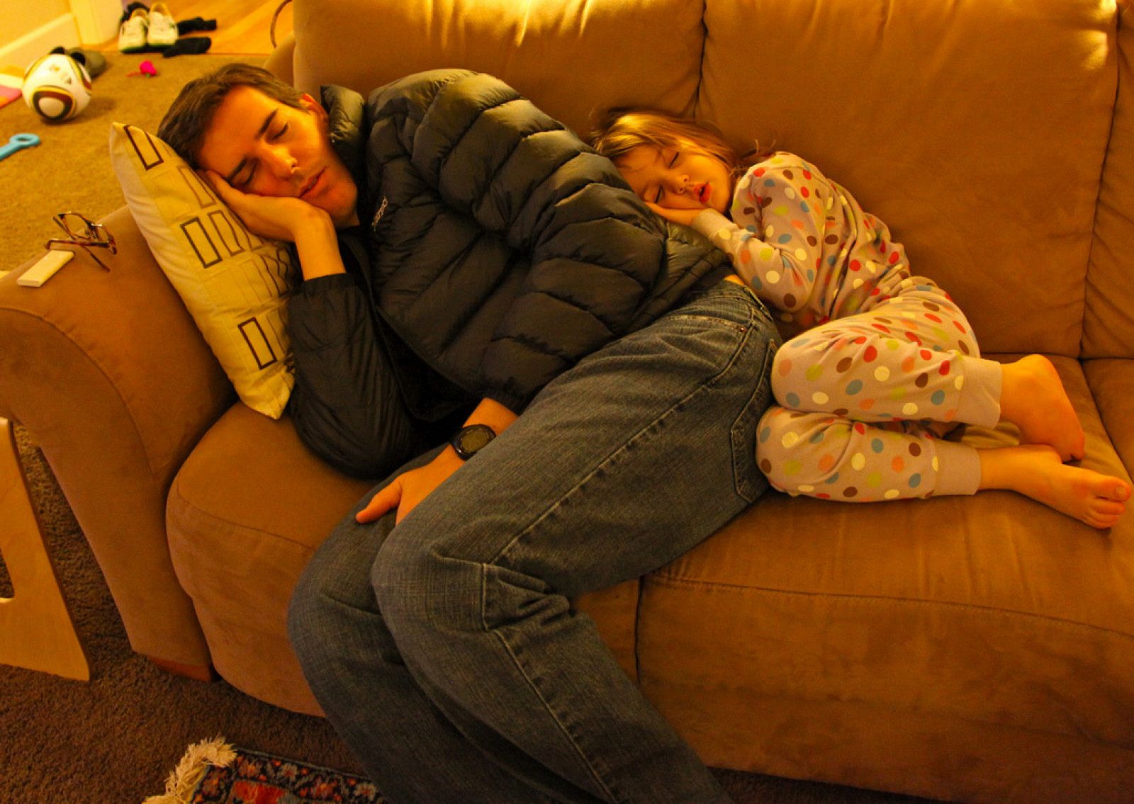Un papá y su niña duermen en el sofá