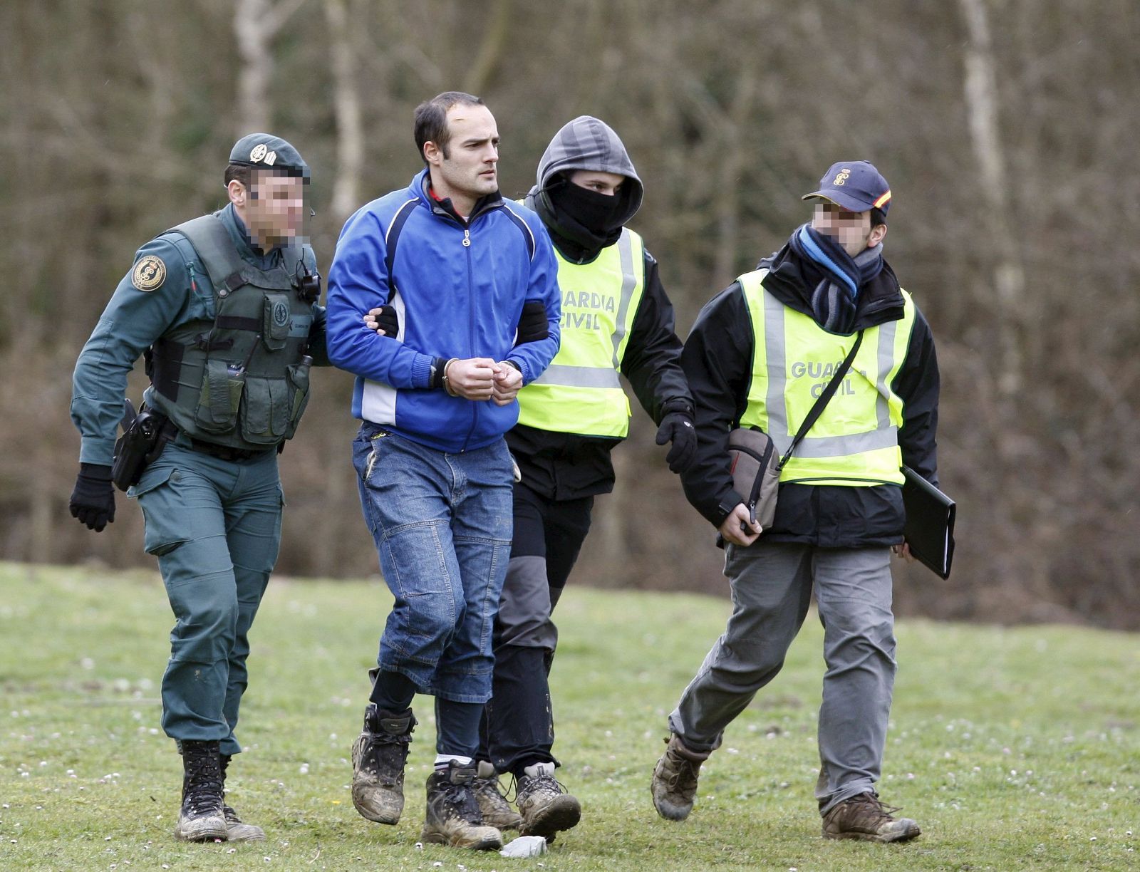 El presunto etarra Ibai Beobide, es conducido al helicóptero por agentes de la Guardia Civil y Policía Nacional.