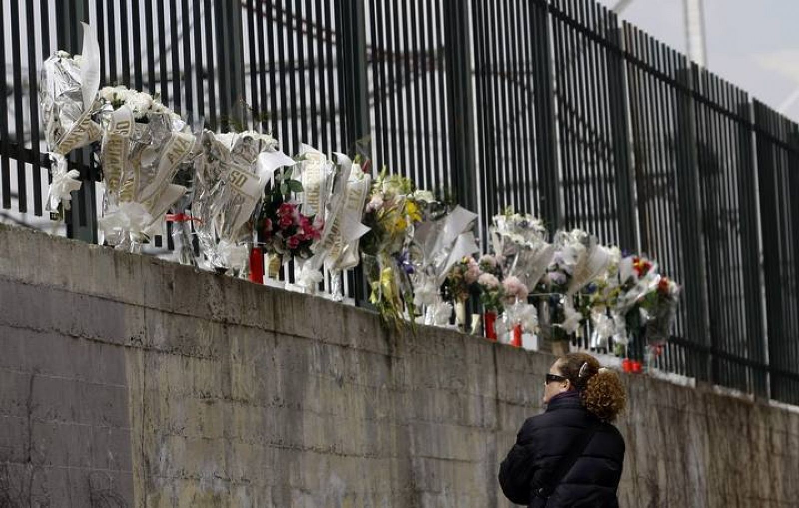 Una mujer observa los ramos de flores colocados en recuerdo de las víctimas del 11M en la calle Téllez 