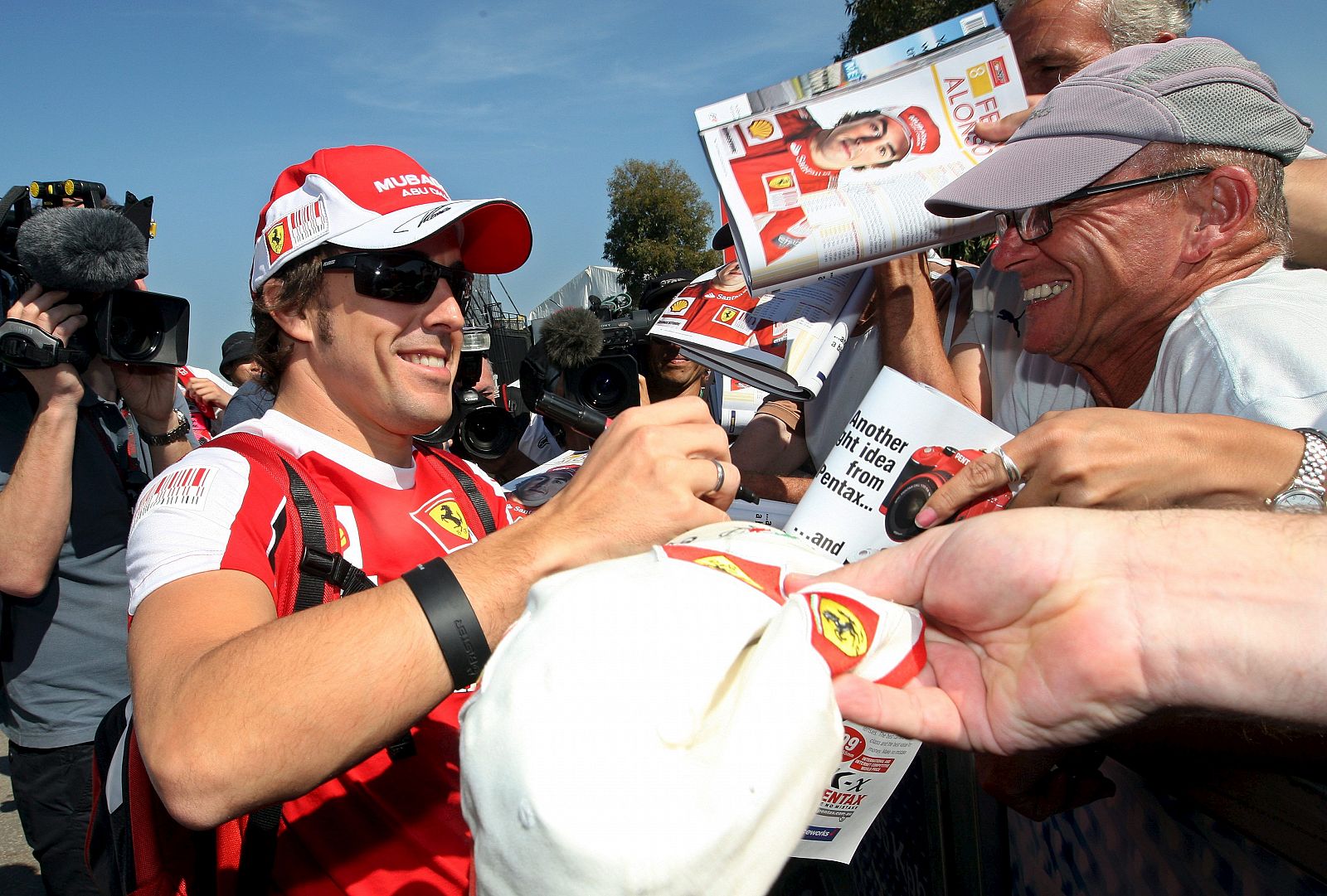 El piloto español de Fórmula Uno Fernando Alonso, de Ferrari, firma autógrafos a su llegada al "paddock" del circuito Albert Park de Melbourne (Australia).