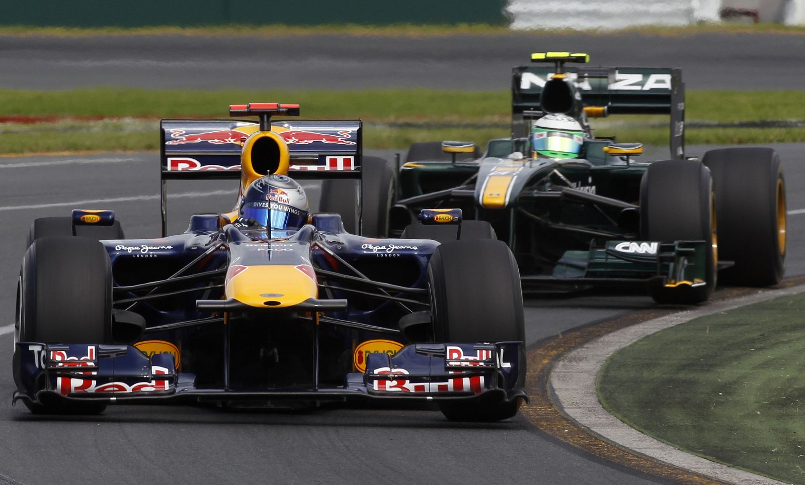 Red Bull Formula One driver Sebastian Vettel of Germany drives ahead of Lotus F1 driver Heikki Kovalainen of Finland during the first practice session of the Australian F1 Grand Prix in Melbourne