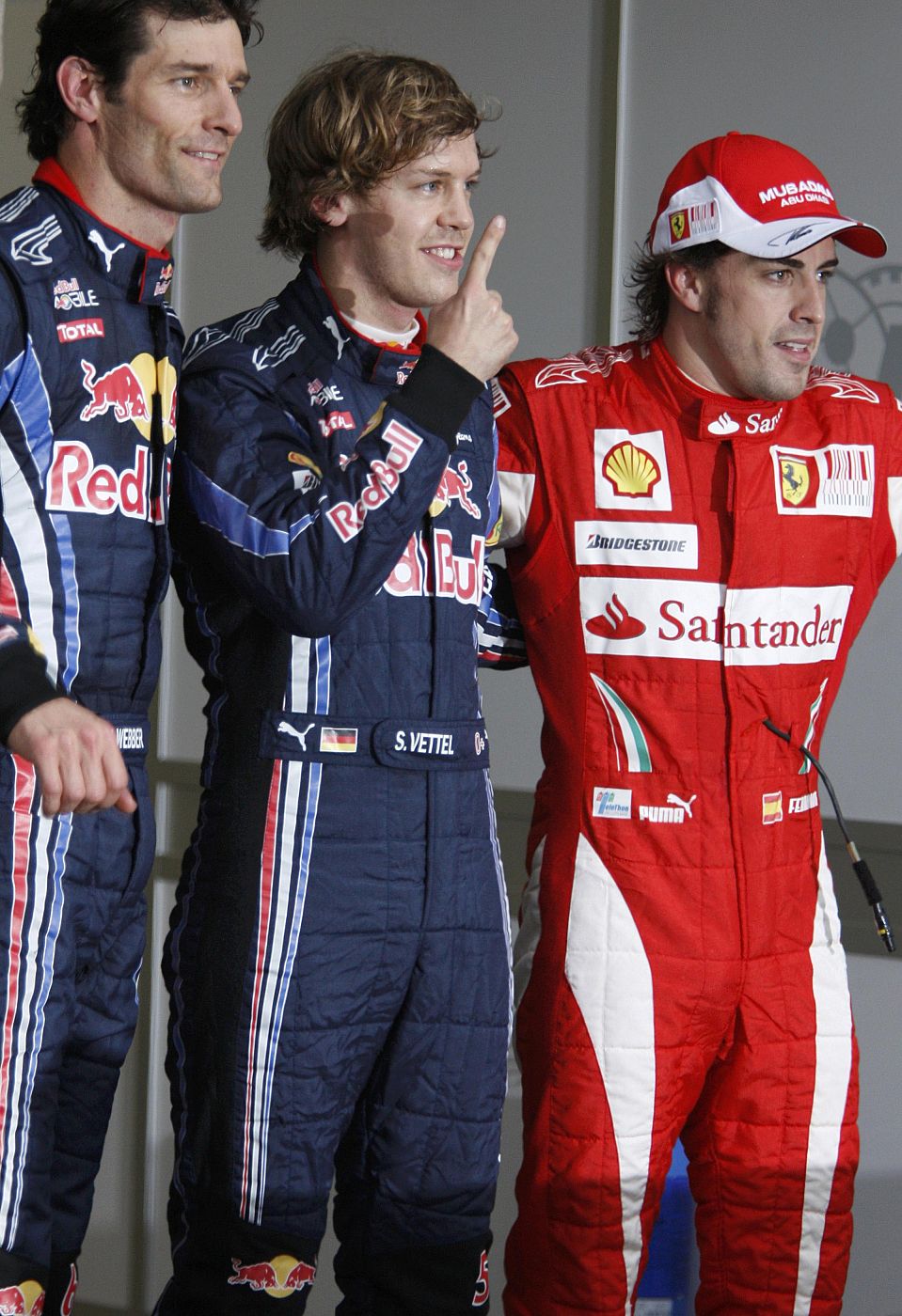 Los pilotos de Red Bull Mark Webber y Sebastian Vettel celebran junto a Fernando Alonso sus primeros puestos en la parrilla de salida