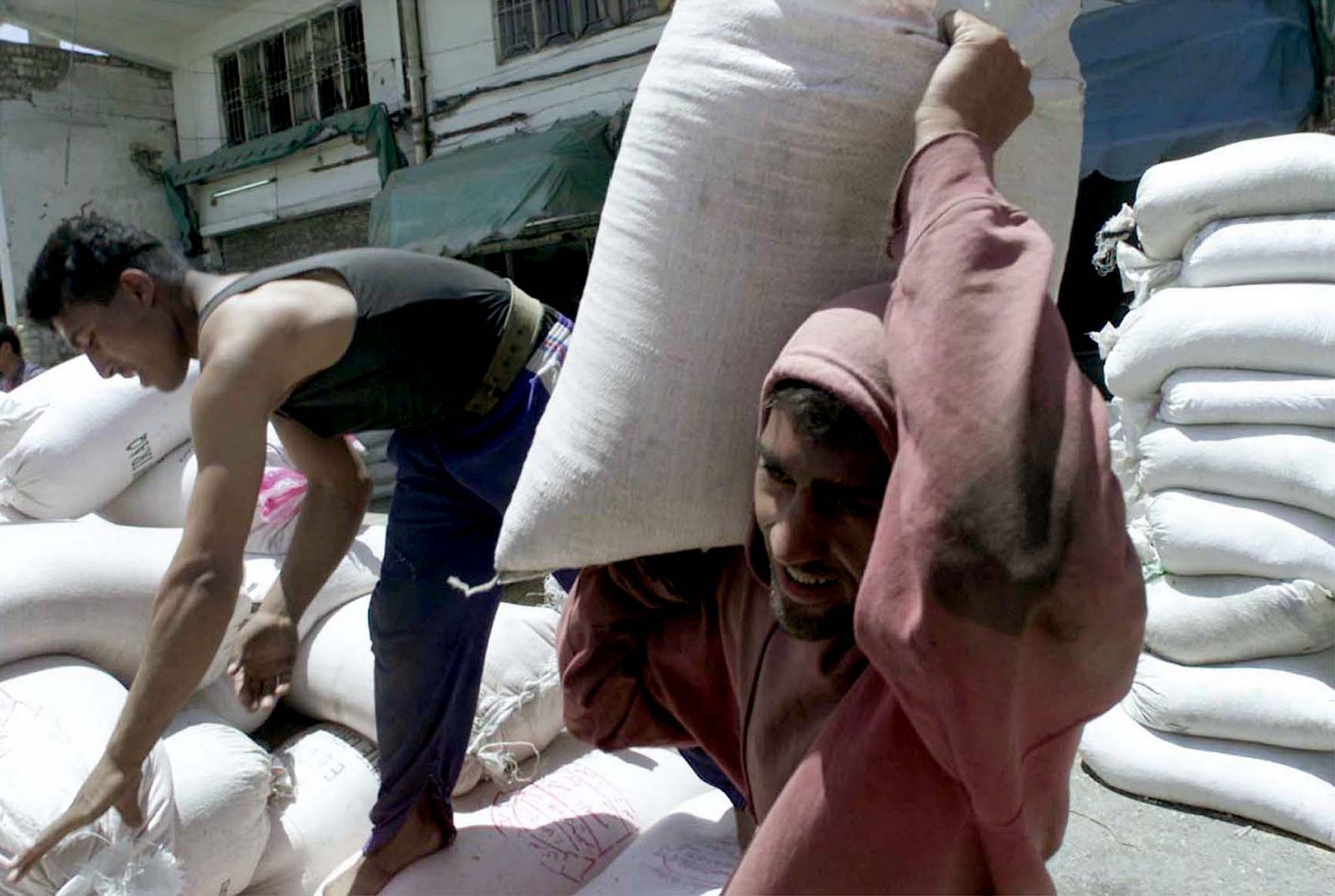 Iraquíes descargan harina llegada por el programa Petróleo por alimentos en 2001.