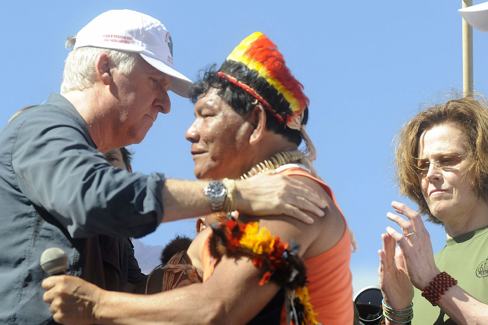 James Cameron (i), y Sigourney Weaver (d), saludan a un indígena brasileño de la región del río Xingú