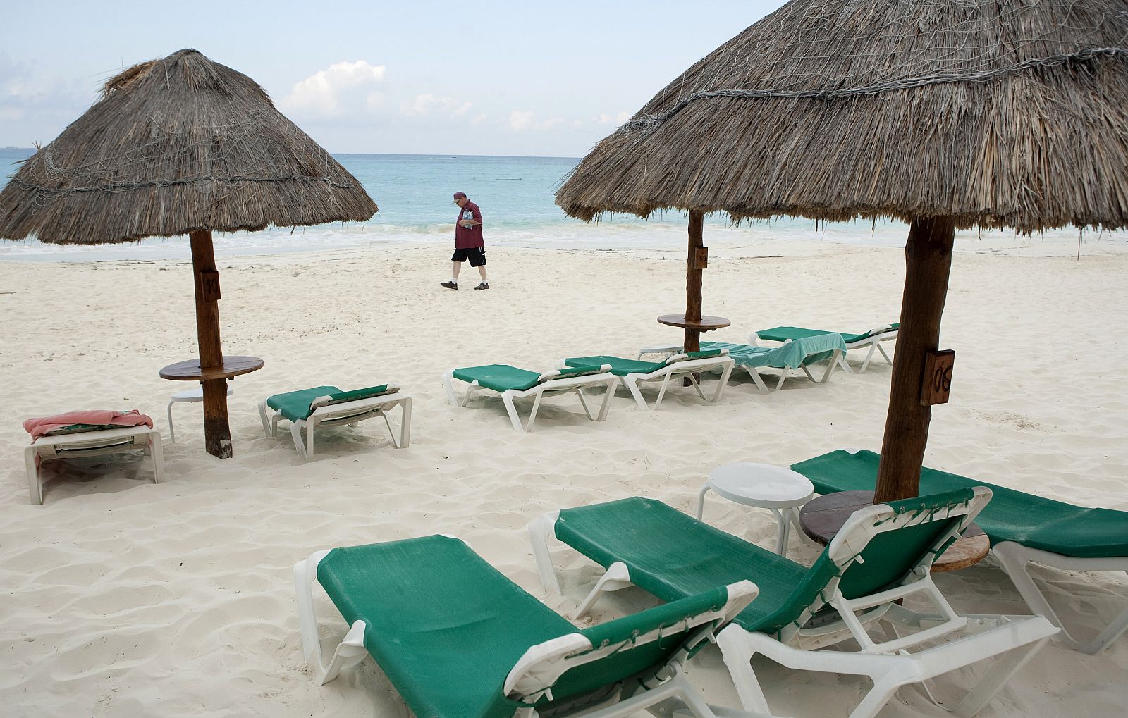 Un turista pasea por una playa vacía