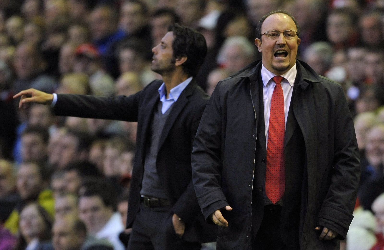 Benítez da instrucciones a los jugadores del Liverpool con Quique (Atlético) de fondo.