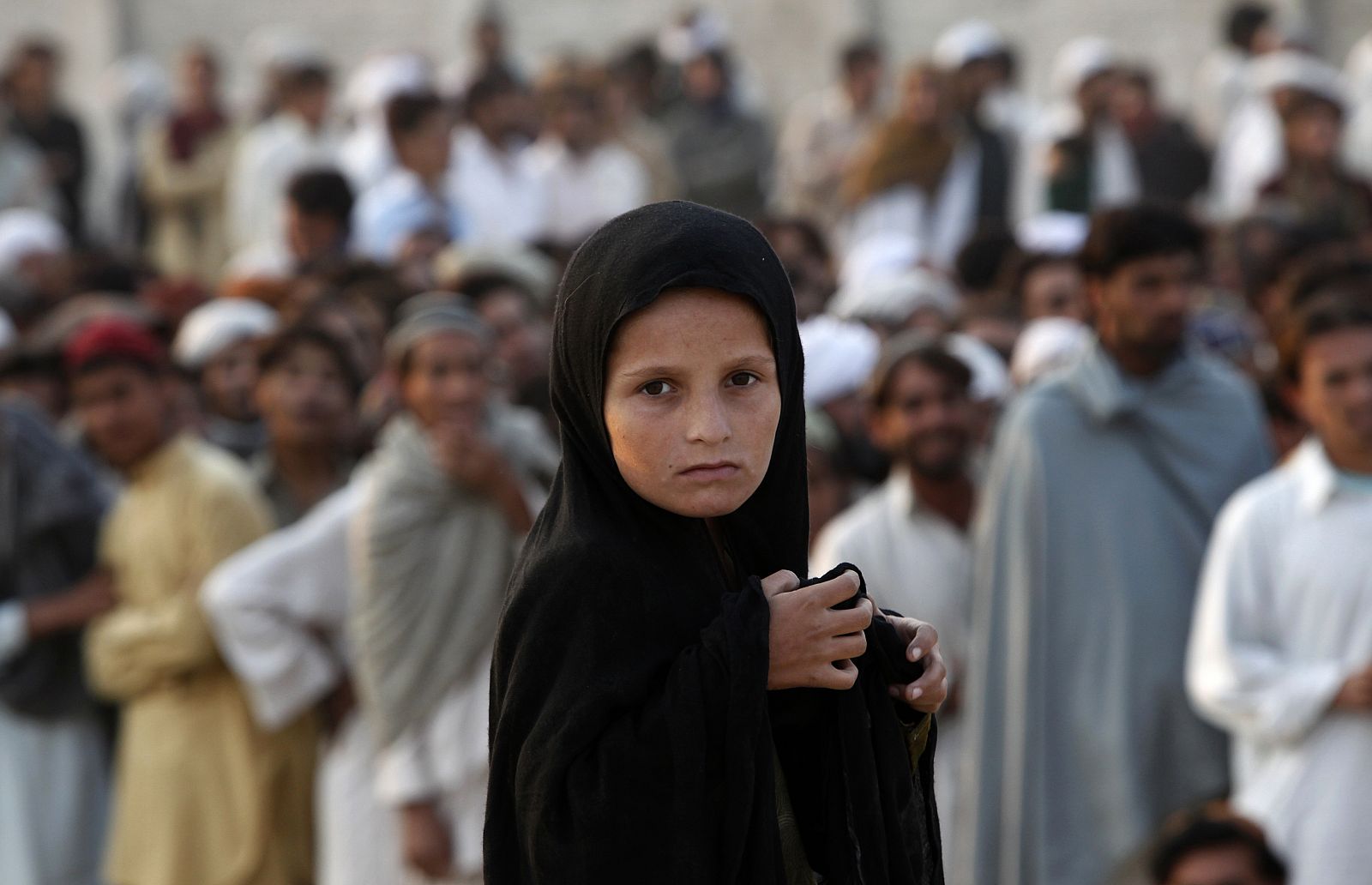 Una niña desplaza interna espera en un punto de distribución de ayuda internacional en Dera Ismail Khan, Pakistán.