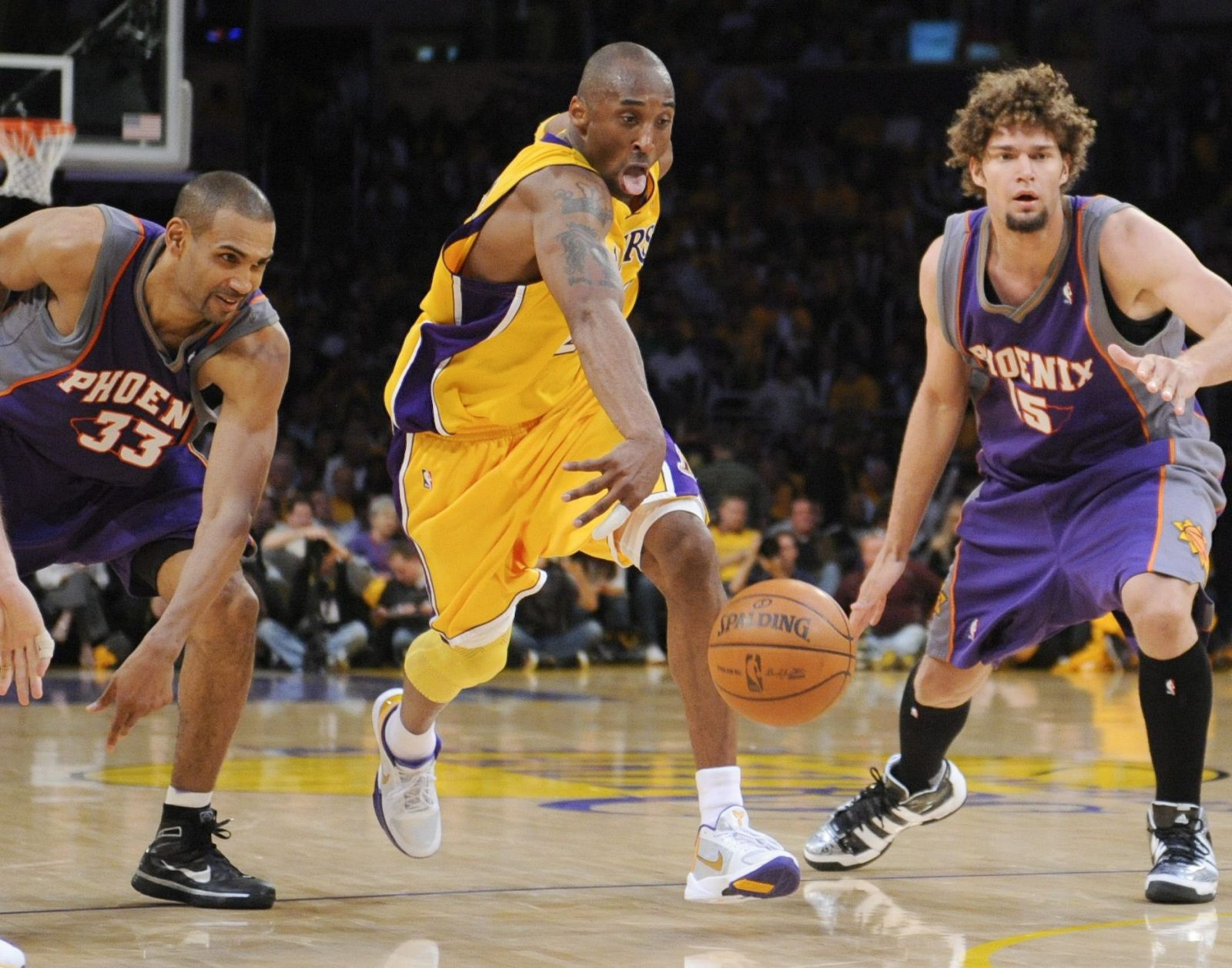 Kobe Bryant disputa el balón a los jugadores de los Suns Grant Hill (izquierda) y Robin Lopez.