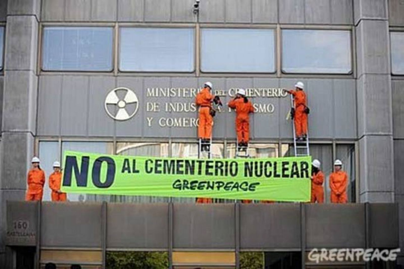 Varios activistas de Greenpeace cambian el rótulo de la fachada del Ministerio de Industria.