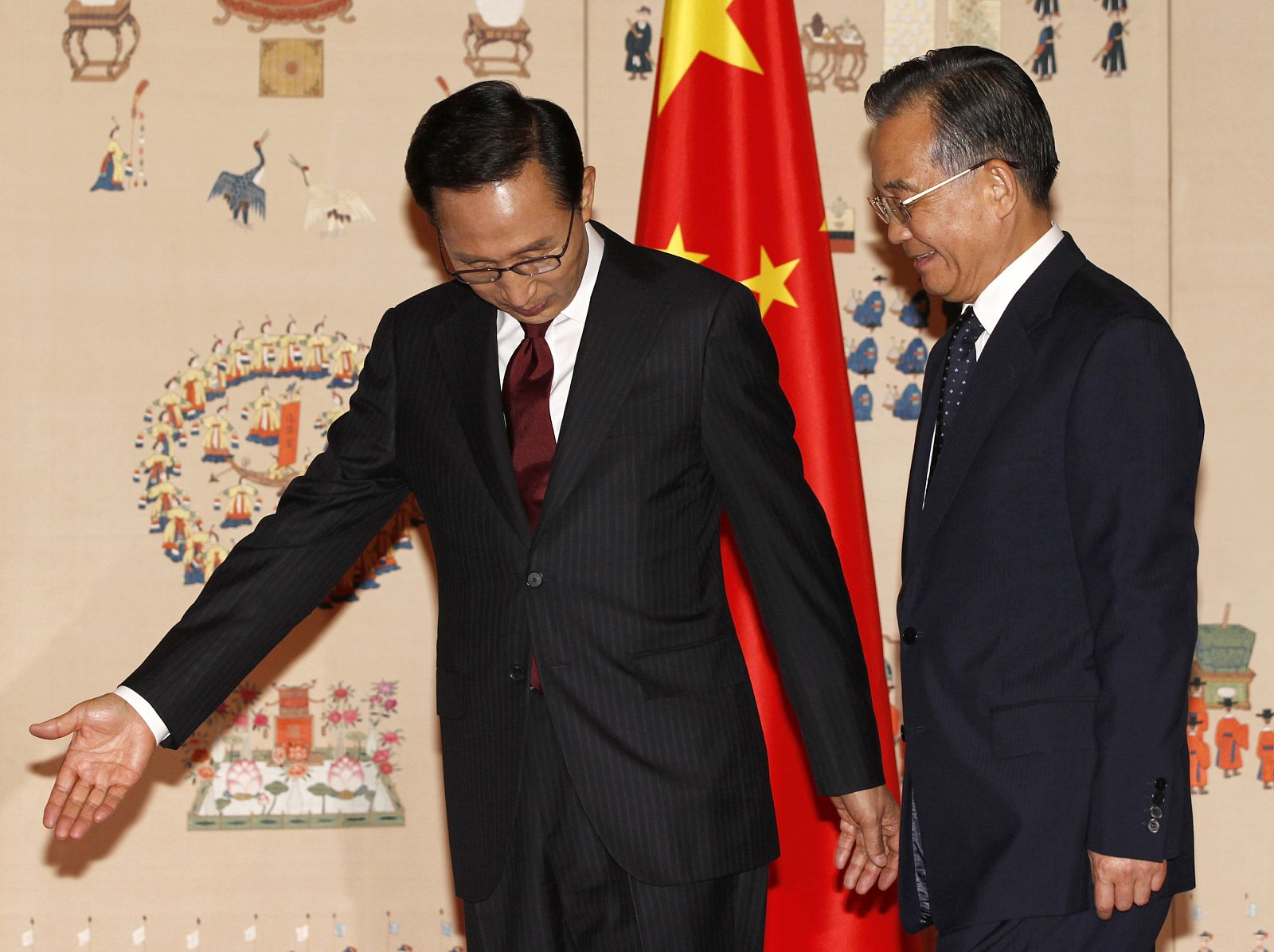 El presidente surcoreano guía al primer ministro chinoi mientras posan para los fotógrafos.