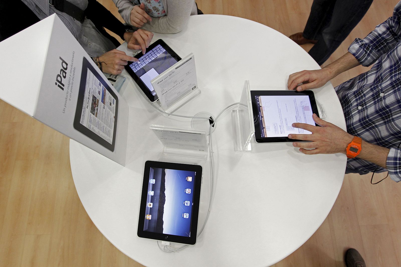 Varios jóvenes prueban el iPad, el nuevo dispositivo de Apple que ya está  en las tiendas españolas, dos meses después de su lanzamiento en Estados Unidos.