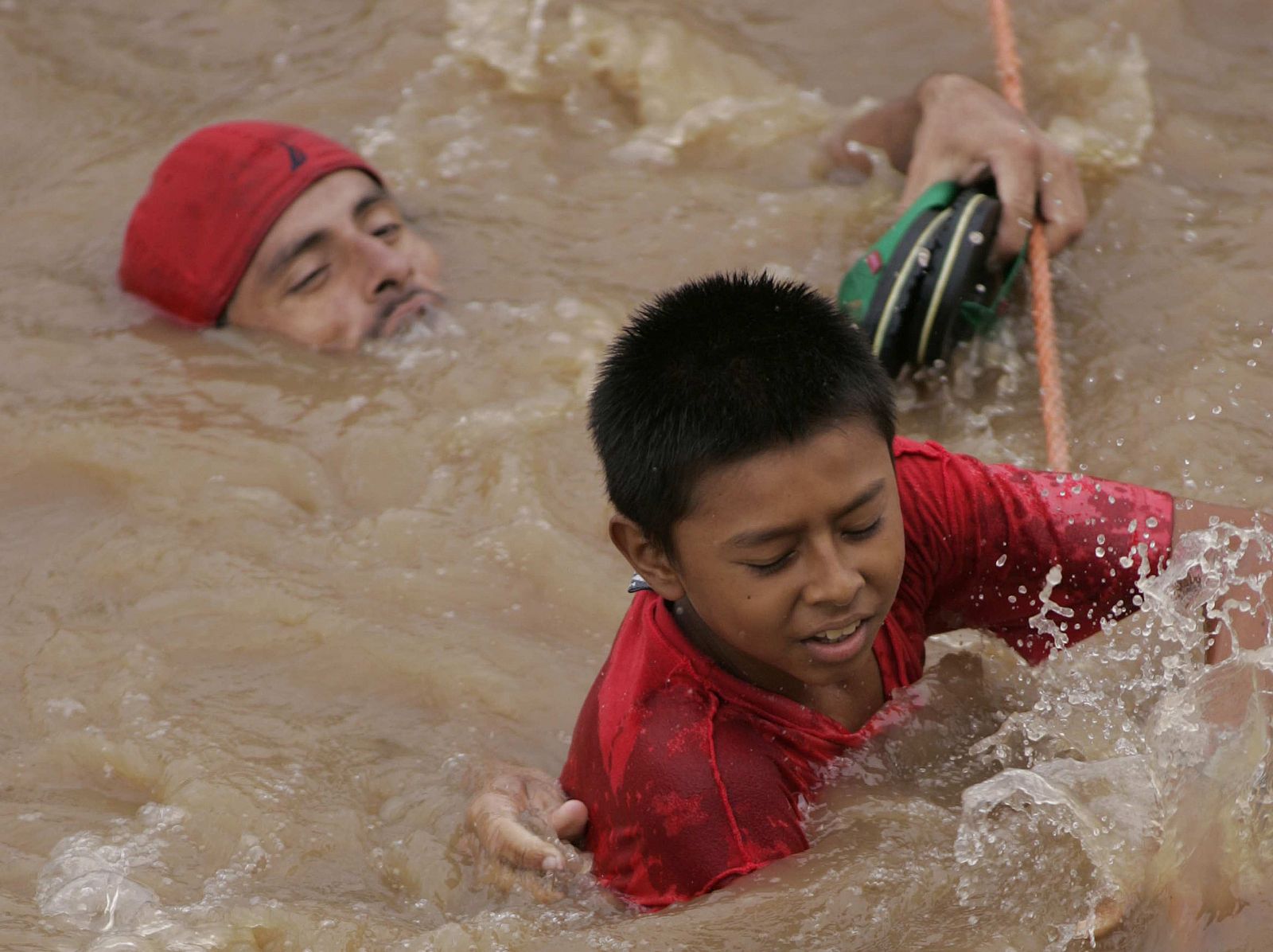 Un hombre ayuda a un niño en La Libertad (Guatemala)