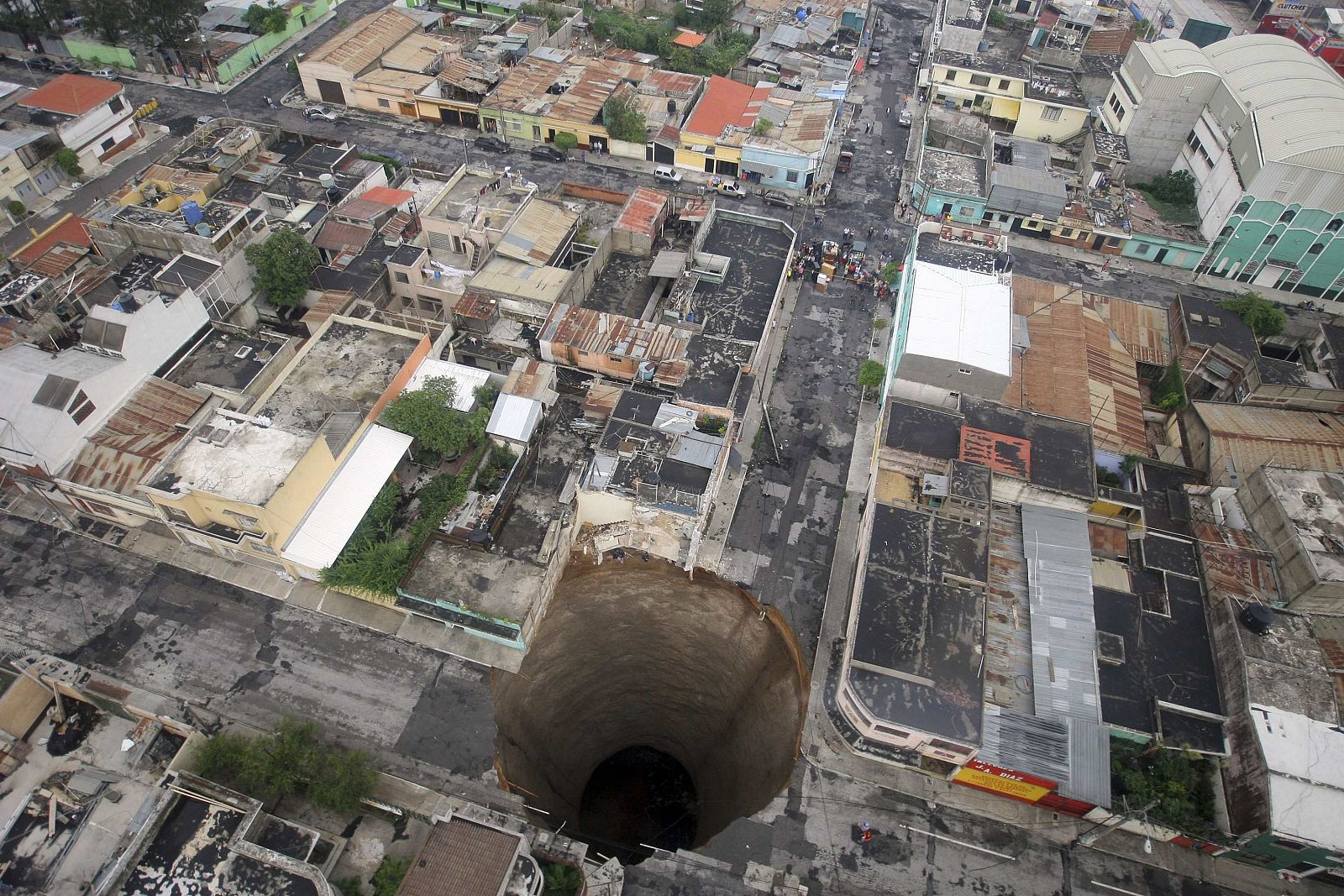 Gran socavón -de 20 m de diámetro y 30 m de profundidad- en el barrio de Ciudad Nueva de la capital de Guatemala.