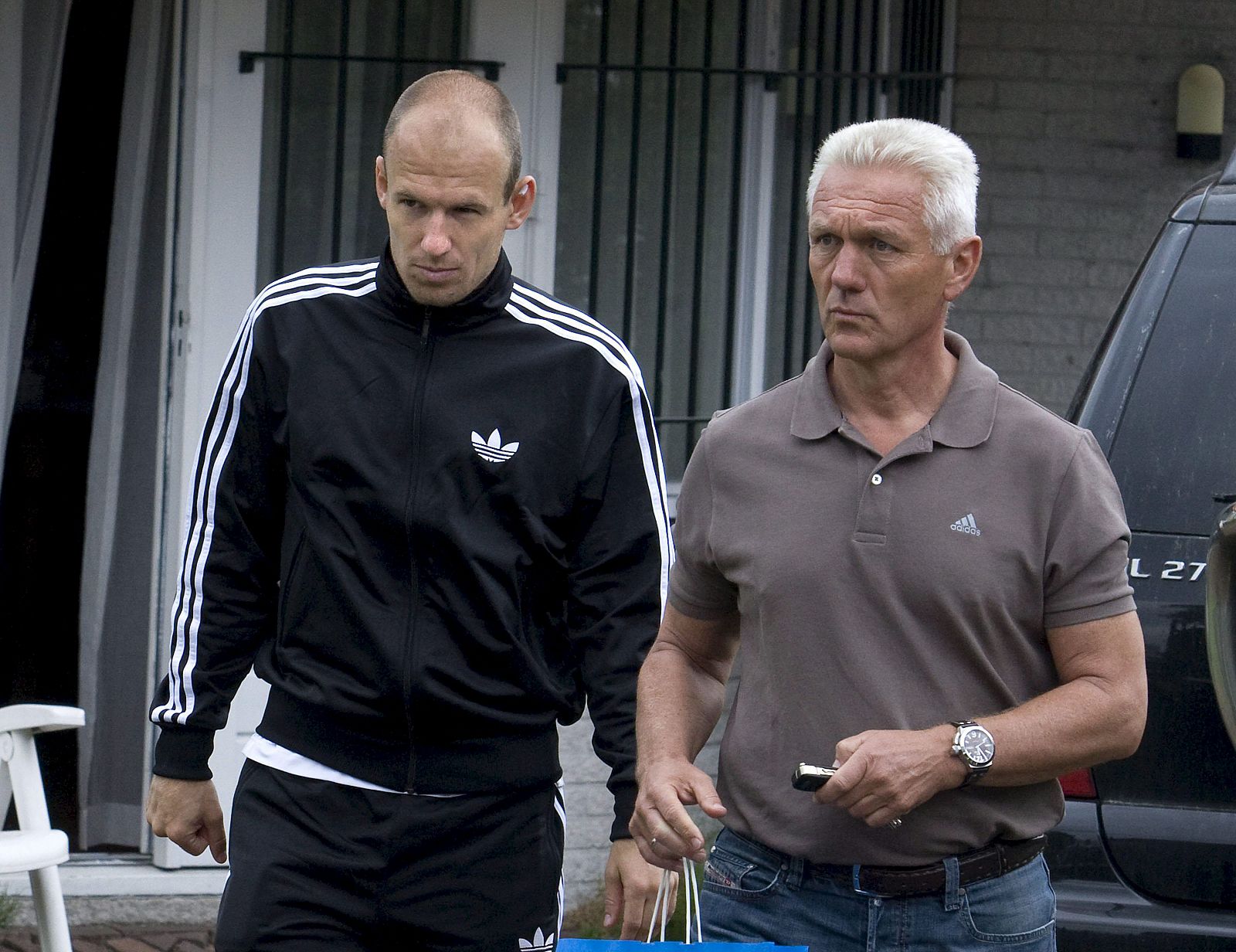 Arjen Robben, junto a su padre, salen de la consulta del fisioterapeuta en Rotterdam.