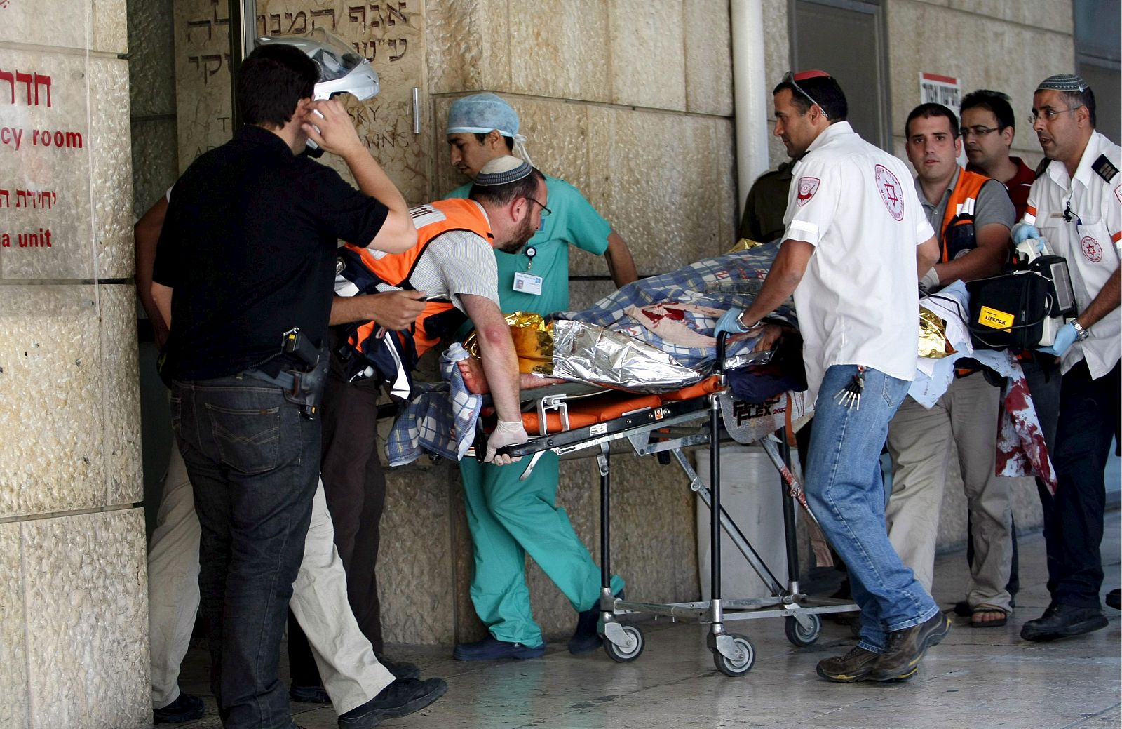 Personal de los servicios sanitarios trasladan en una camilla a un policía israelí herido, en el hospital Ein Kerem Hadassah, a las afueras de Jerusalén.