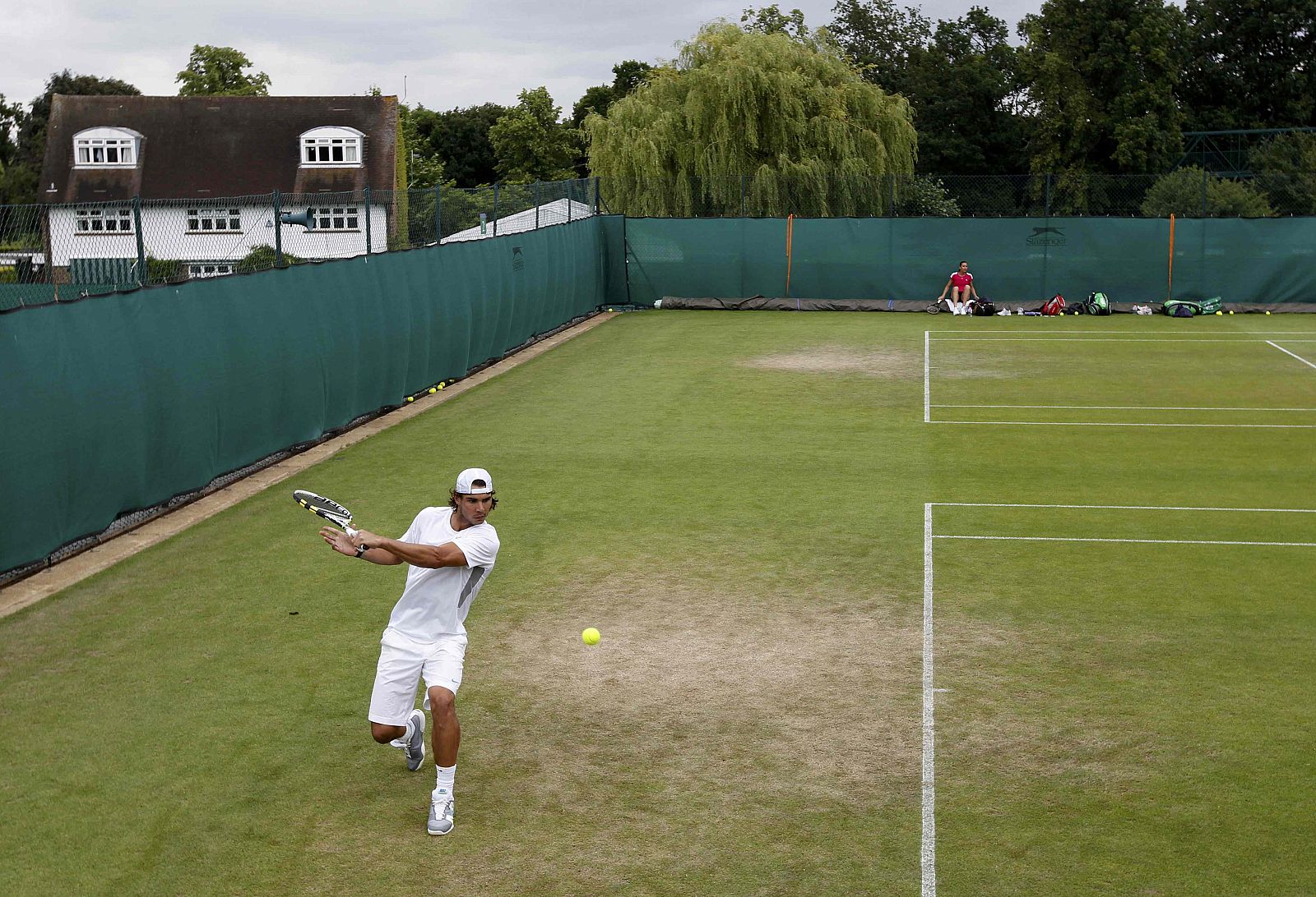 Nadal practica en la pista de entrenamiento antes de debutar en Wimbledon este martes.