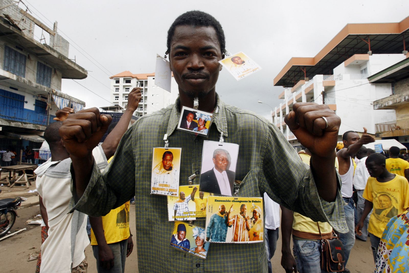 Un guineano con las fotografías del candidato del partido RPG, Alpha Conde, uno de los favoritos