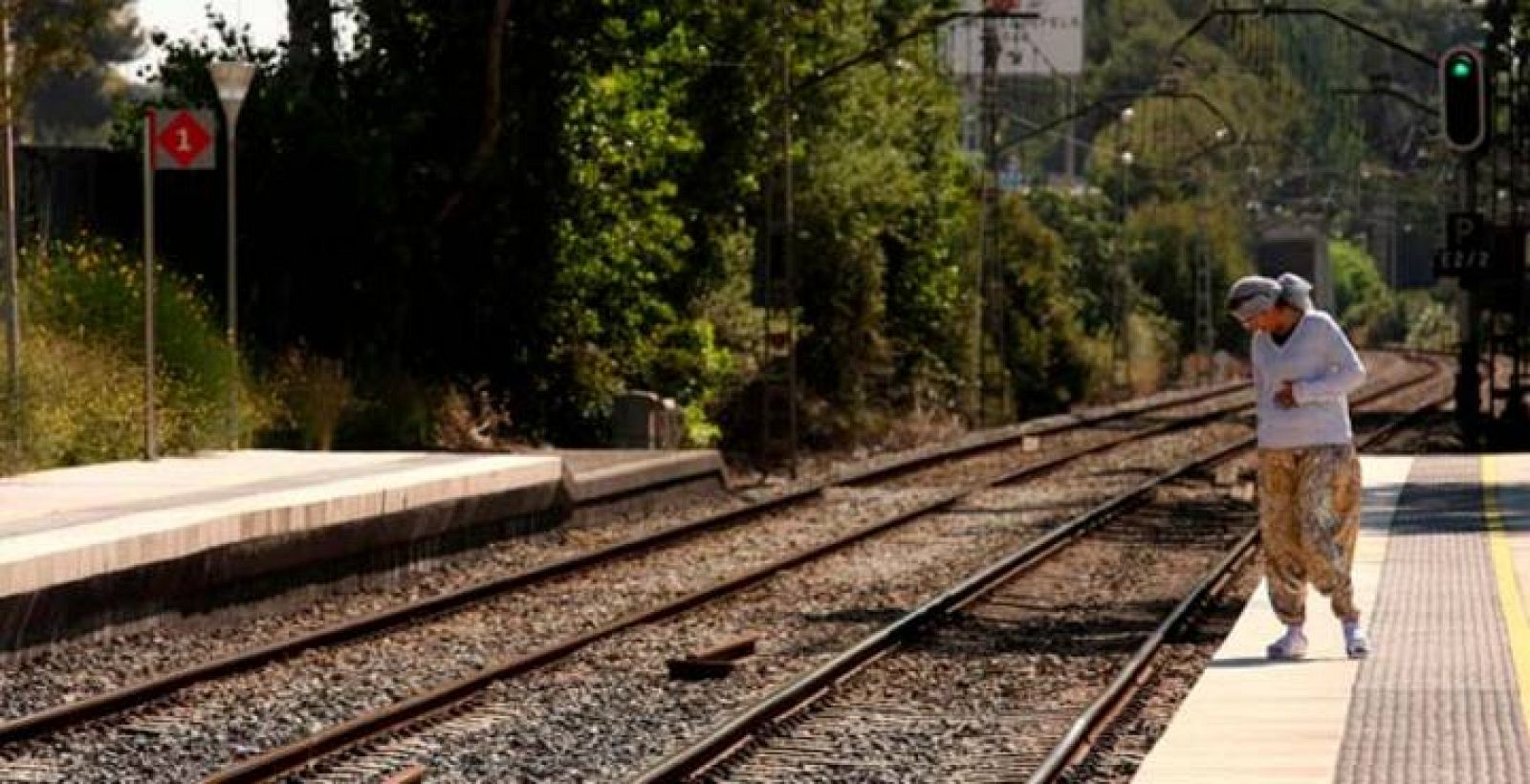 Una mujer observa las vías de tren de la estación de Castelldefels Platja donde tuvo lugar el fatal accidente de tren que causó 13 víctimas mortales la noche en que se celebraba la festividad de San Juan.