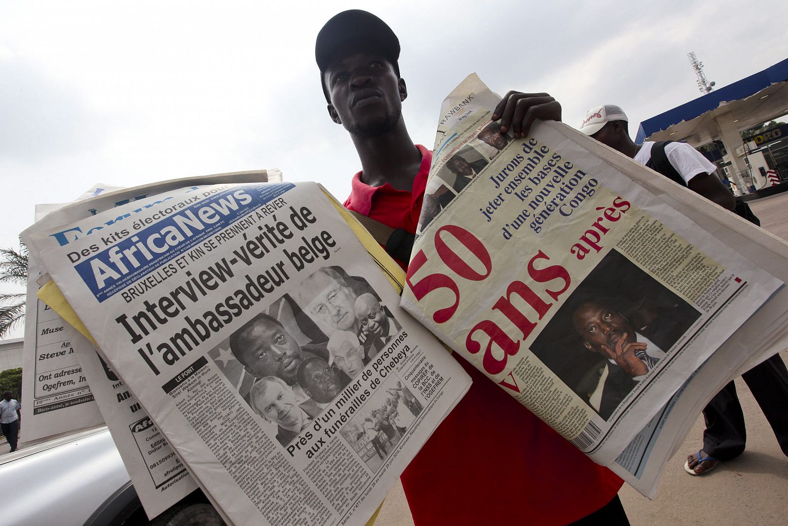 Un hombre vende periódicos en los cuales se habla acerca de la celebración del 50 aniversario