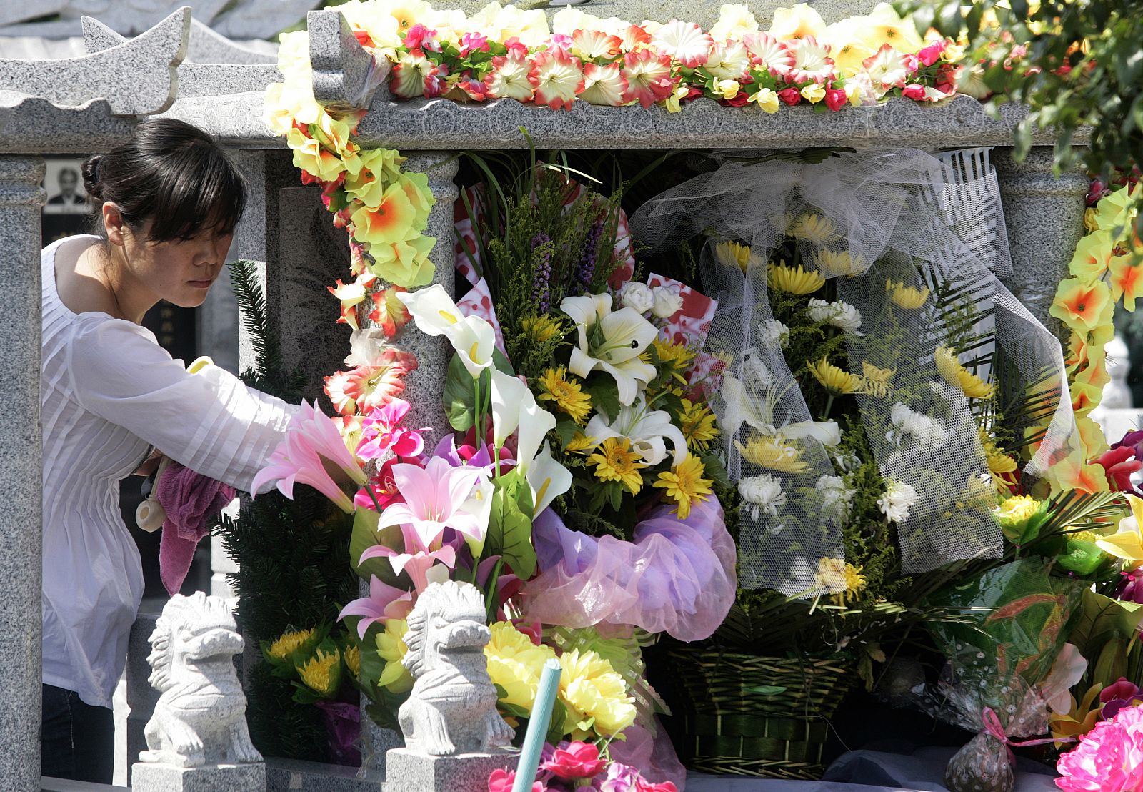 Una mujer deja unas flores en el Parque Memorial del Martirio en Urumqi que recuerda a las víctimas de los disturbios étnicos que se produjeron hace un año.