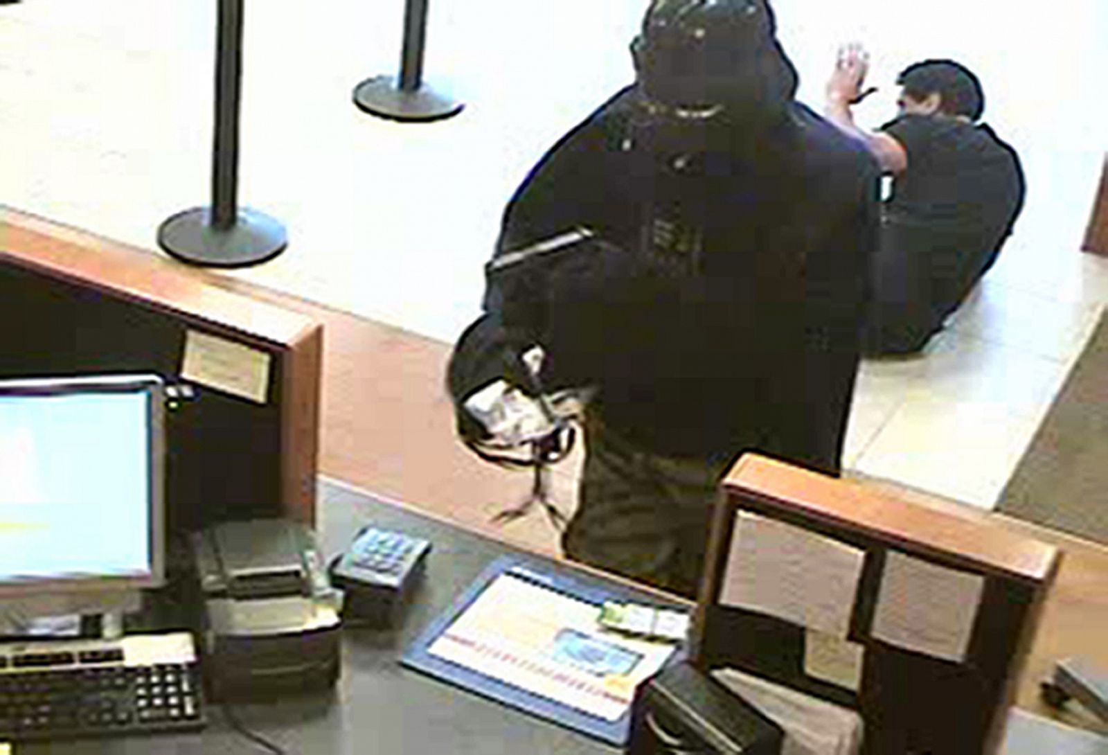 El ladrón disfrazado de casco oscuro, captado por las cámaras de seguridad del banco.