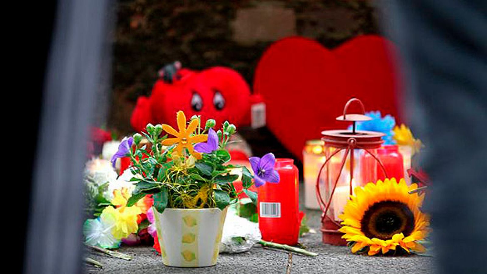 Flores y velas recuerdan a las 21 víctimas en el lugar de la tragedia