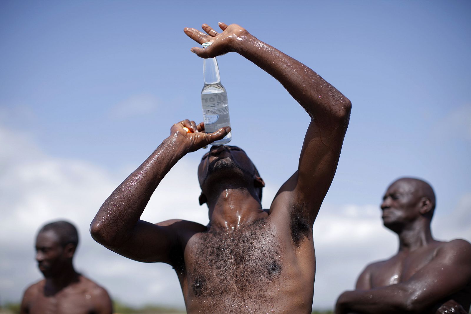 Un hombre besa una botella de agua en Haití