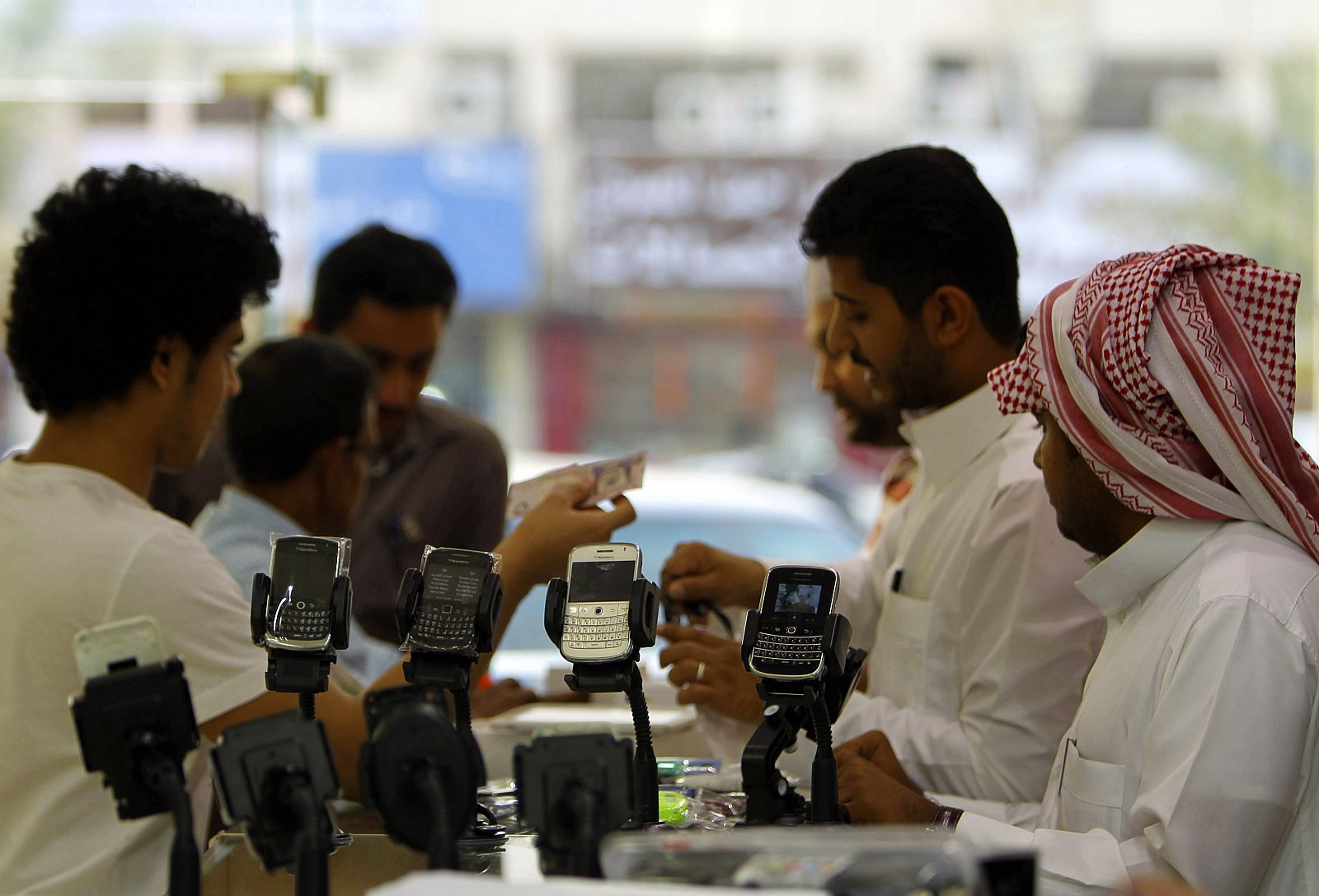 Men stand near BlackBerry phones on sale at a shopping mall in Riyadh