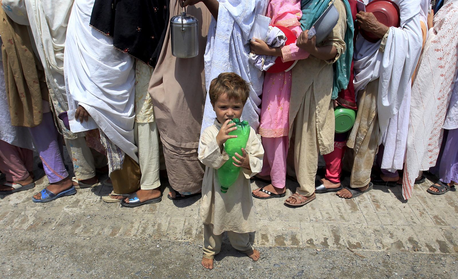 Un pequeño paquistaní espera para recibir alimento