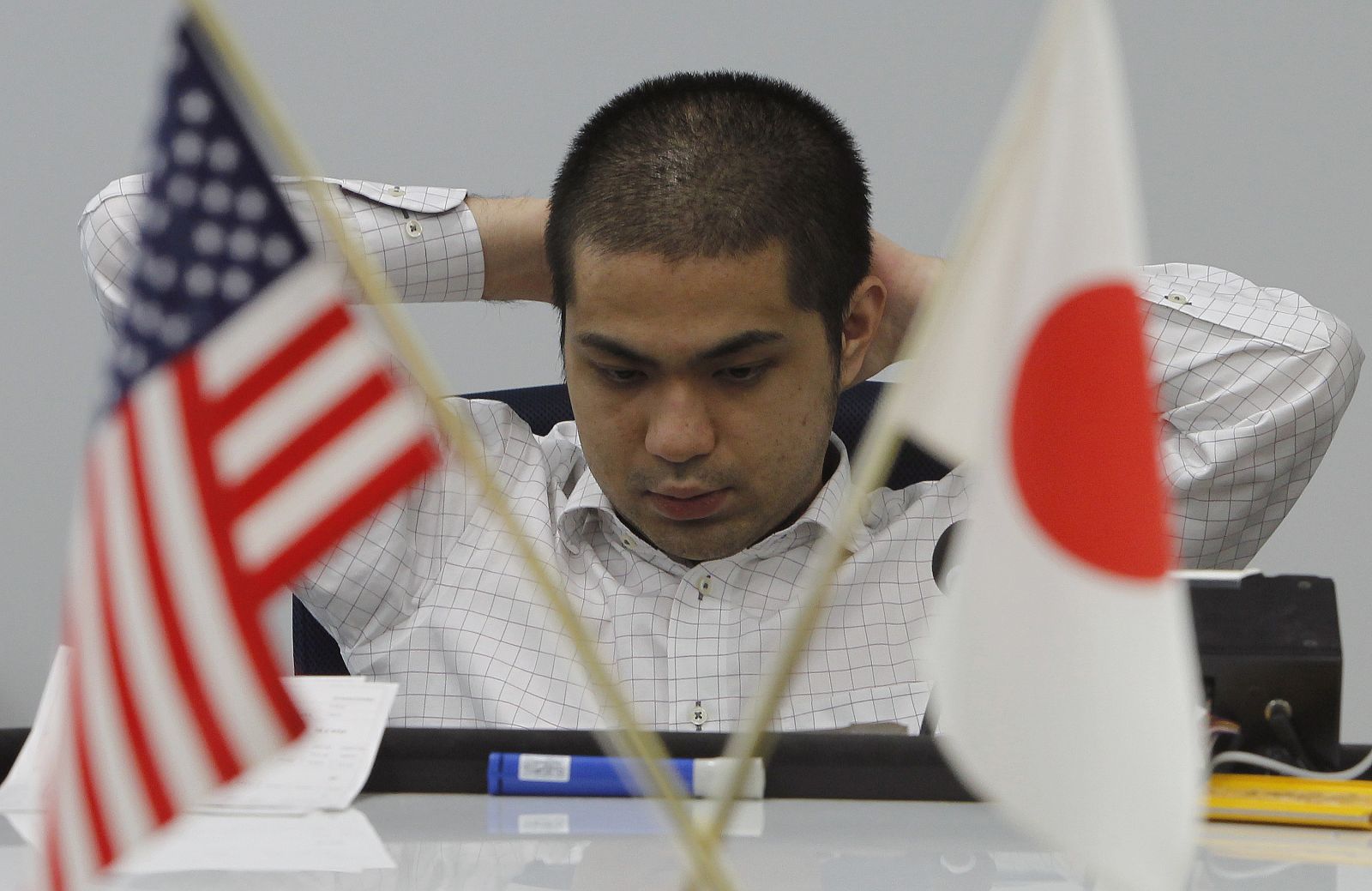 A foreign exchange dealer monitors an electronic board displaying the Japanese yen's exchange against the U.S. dollar at a foreign exchange brokerage in Tokyo