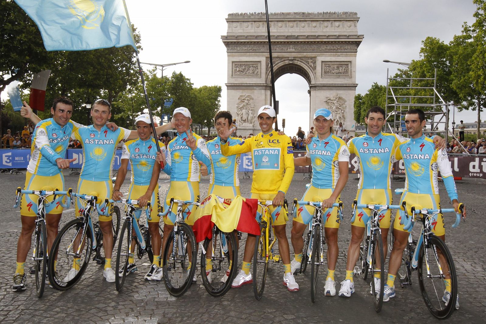 Astana team rider and leader's yellow jersey Alberto Contador of Spain poses with teammates in front the Arc de Triomphe on the Champs Elysees in Paris