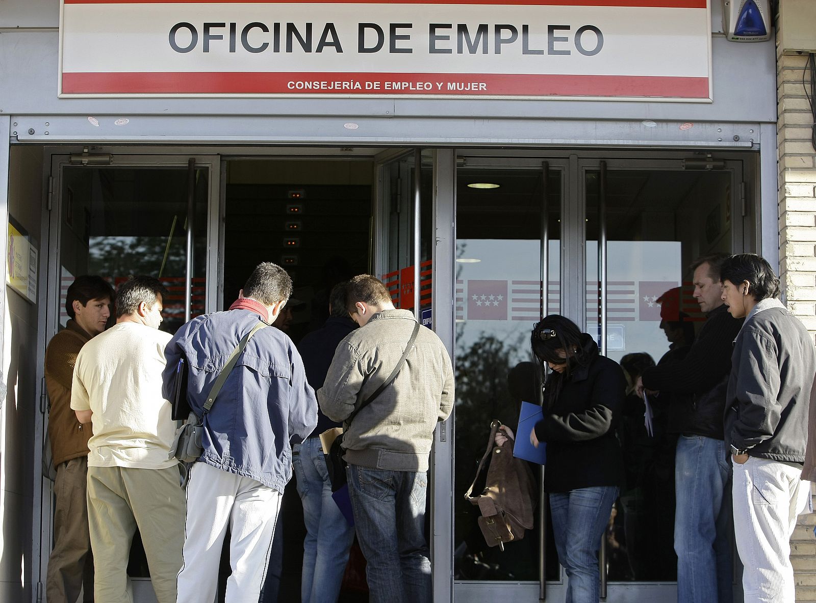 People line up to enter a government job centre in Madrid