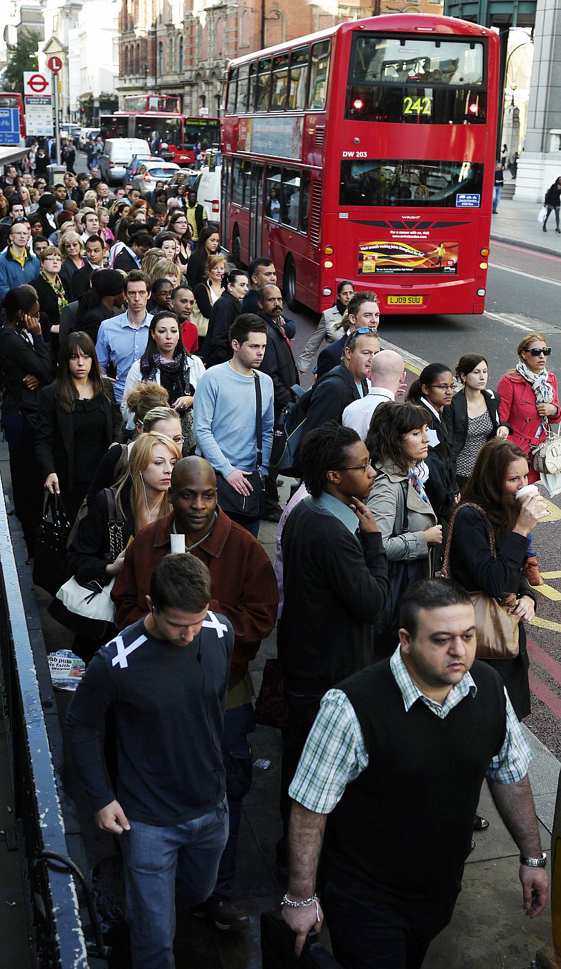 Commuters queue for buses during a strike by underground transit workers, outside Liverpool Street rail station in London