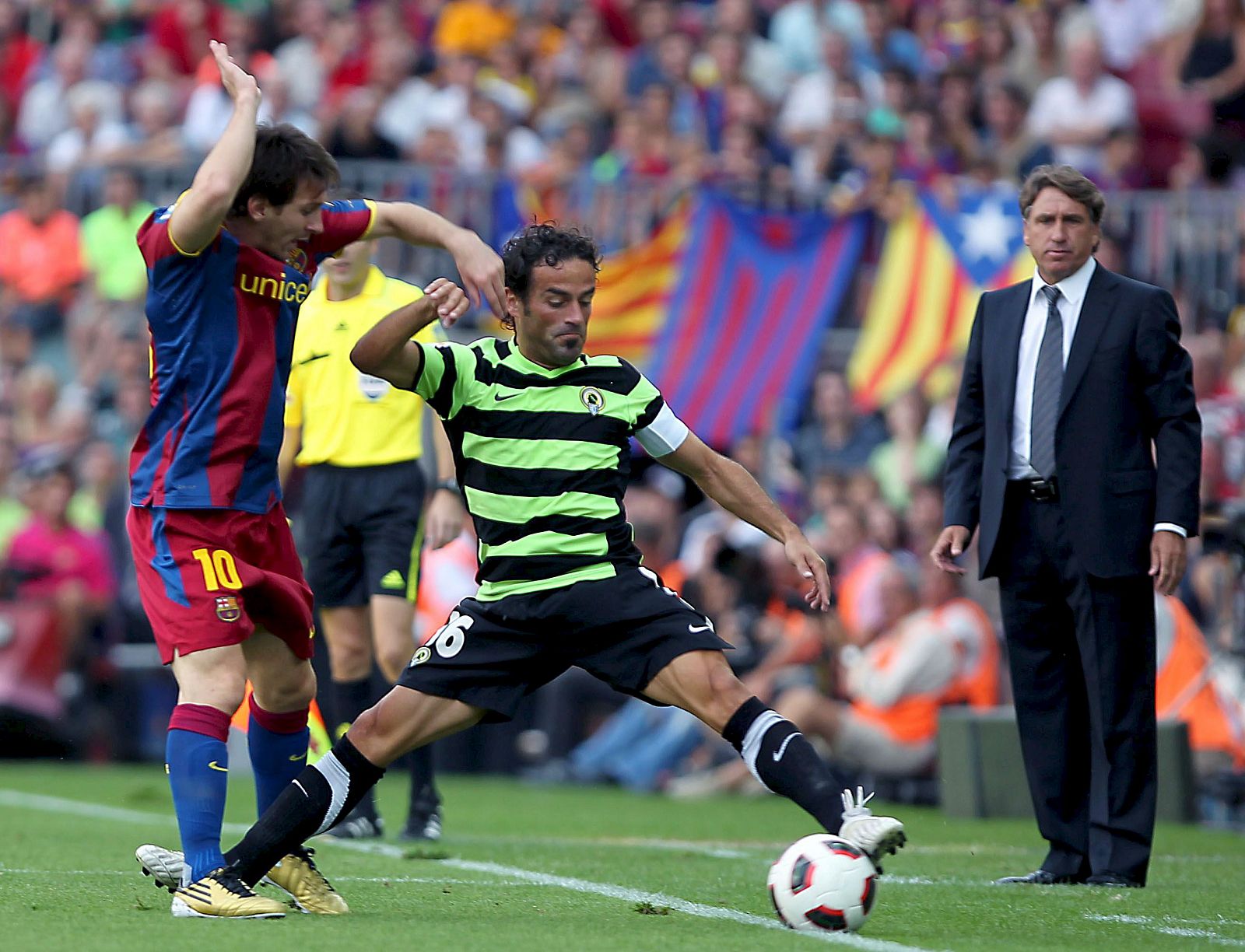 El delantero argentino Lionel Messi lucha un balón con el defensa del Hércules Abraham Paz.