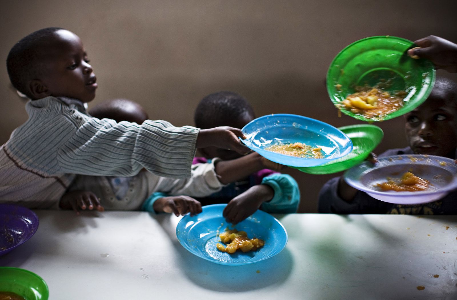 Children who have been abandoned or orphaned by war eat dinner in eastern Congo